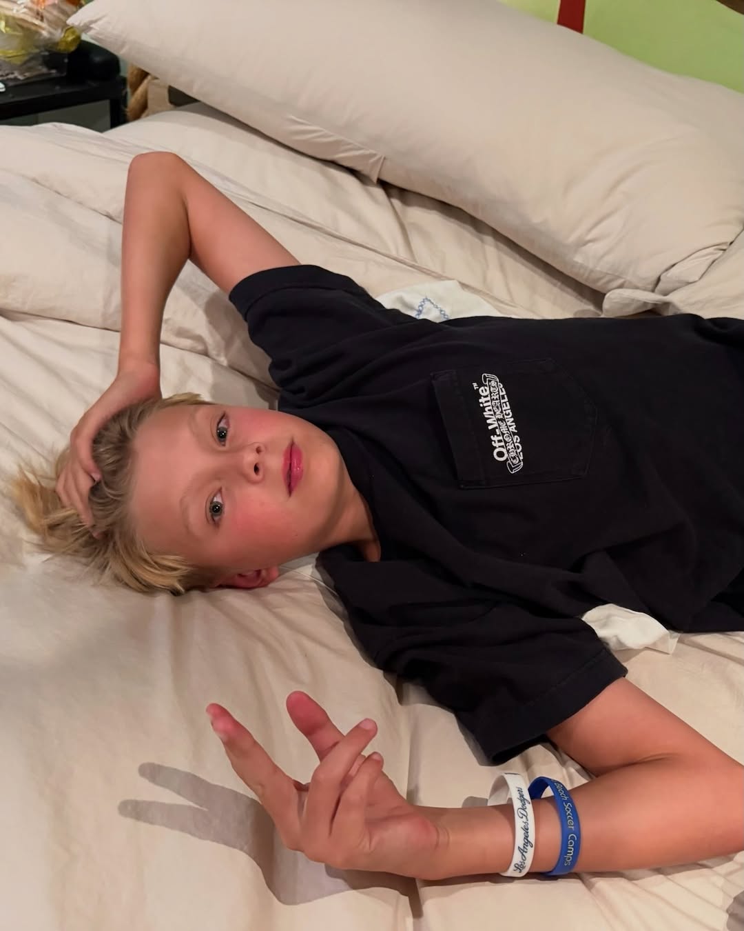 Fergie's son Axl Duhamel lying in bed, from her birthday tribute posted on August 29, 2025 | Source: Instagram/fergie