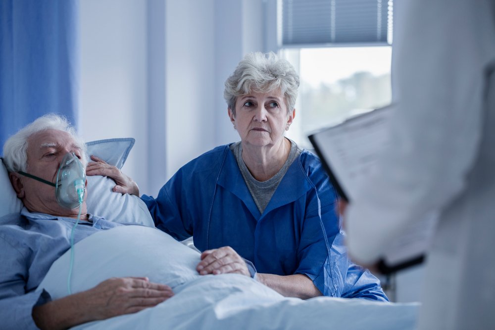 Photo of a woman by her husband's side in the hospital. | Photo: Shutterstock.