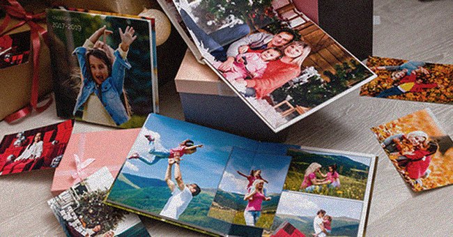 A photo album lies on a table a features multiple family pictures | Photo: Shutterstock