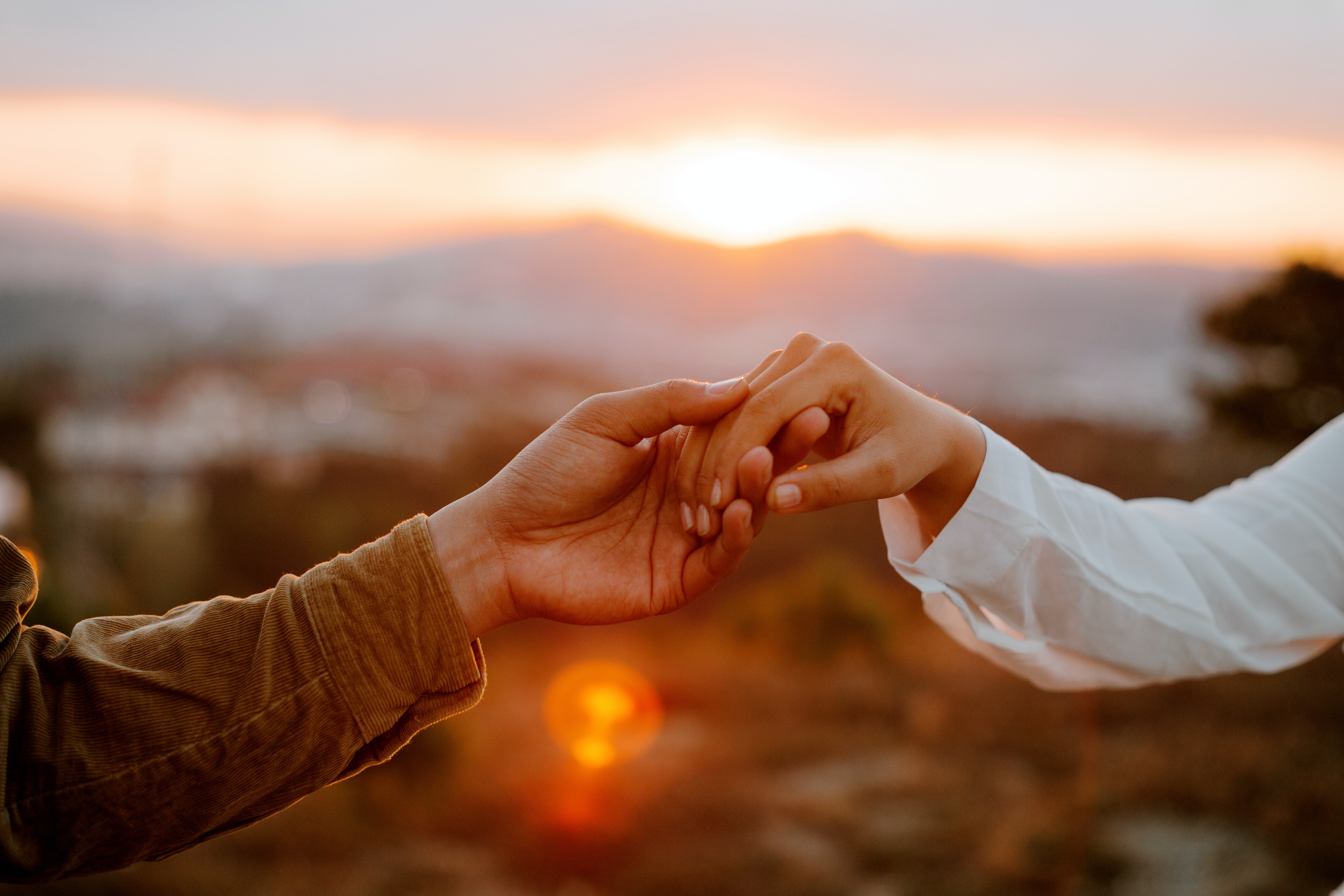 Couple holding hands at sunset. | Source: Pexels