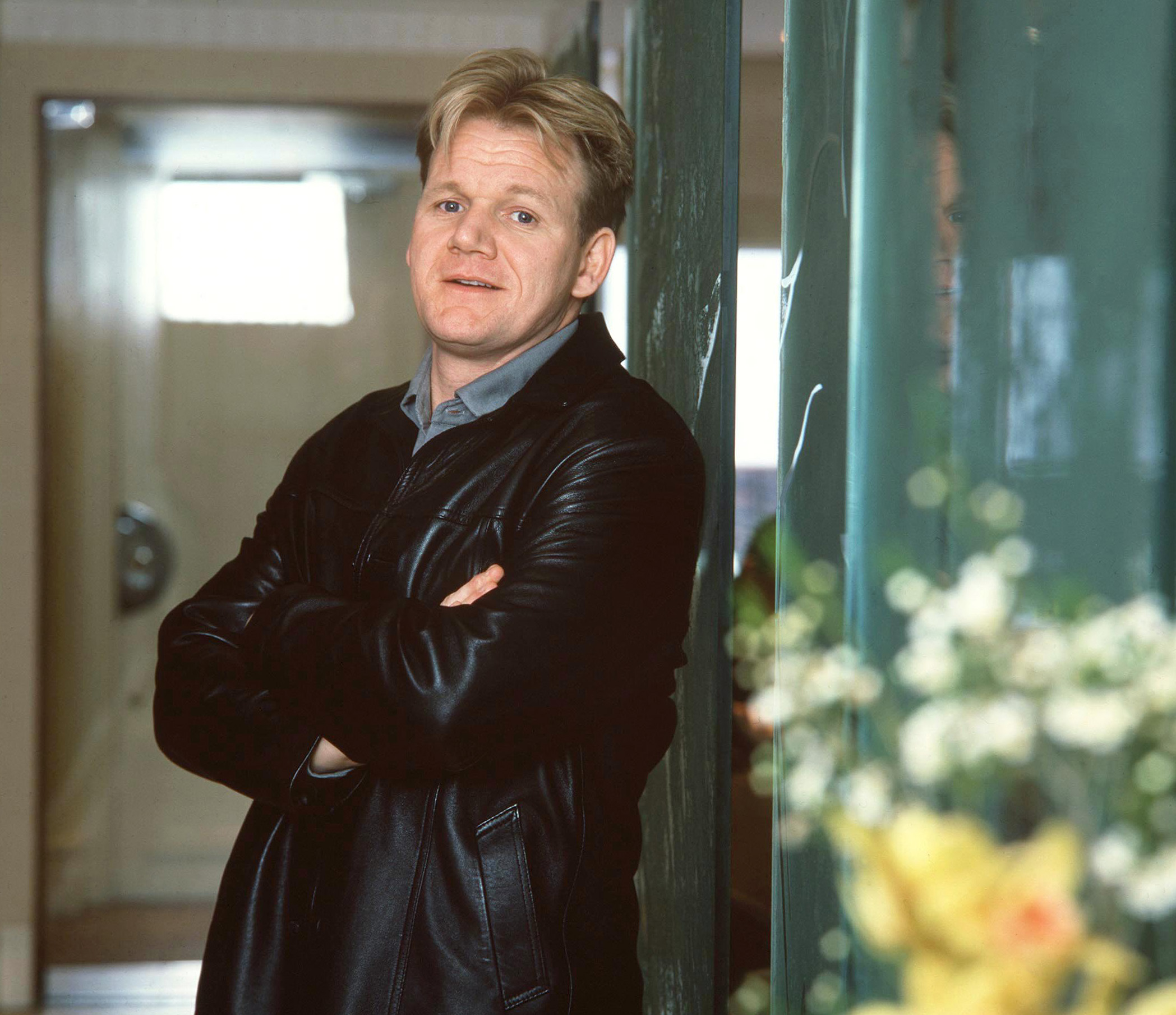 Gordon Ramsay stands arms-crossed in the doorway of his London restaurant in March 2001 — cropped blond hair, a black leather jacket, and the same strong jaw and pale blue eyes that would later reappear on his son.