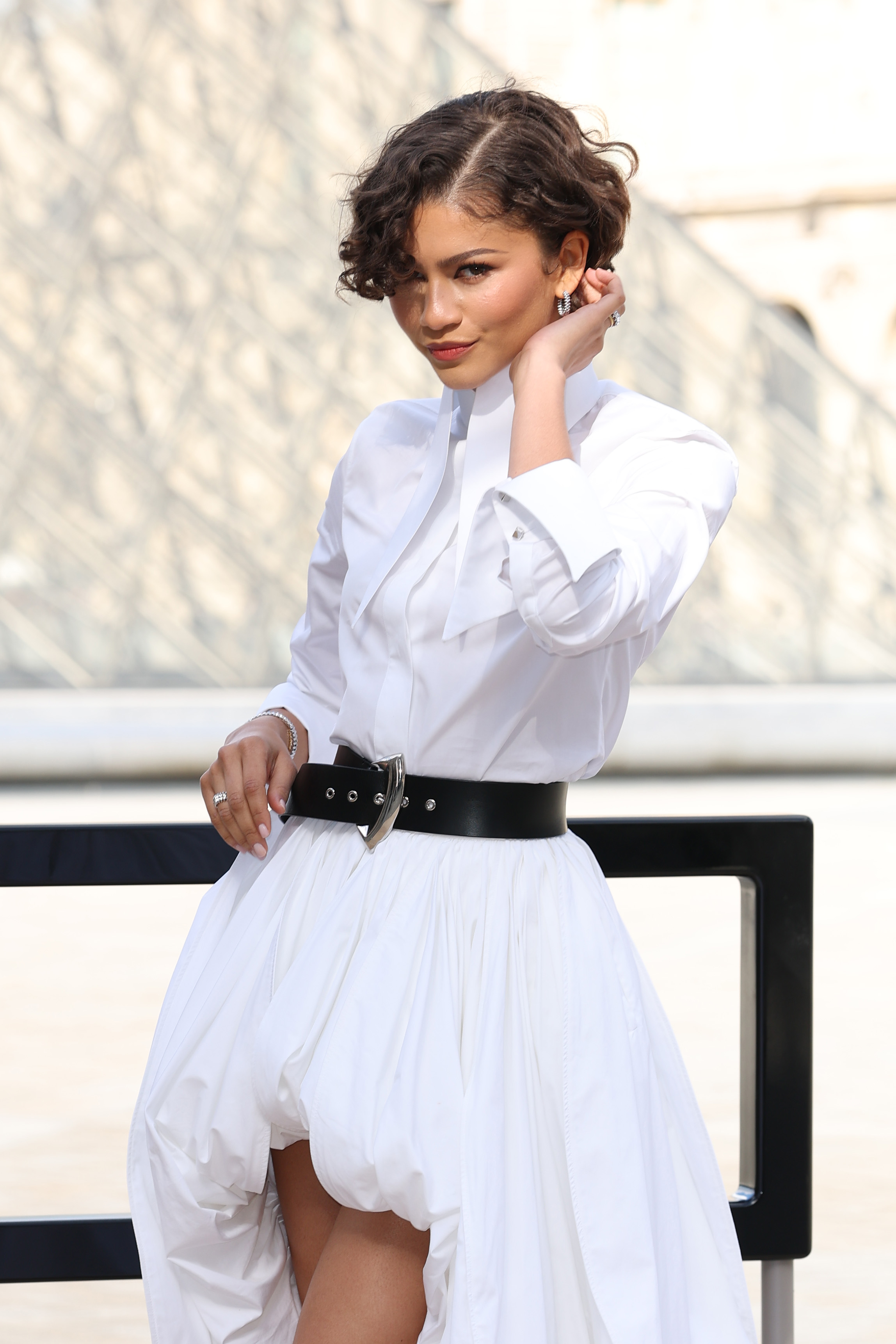 Zendaya poses outdoors in front of a softly blurred stone backdrop at the Louis Vuitton Fall/Winter show during Paris Fashion Week in France on March 10, 2026. | Source: Getty Images