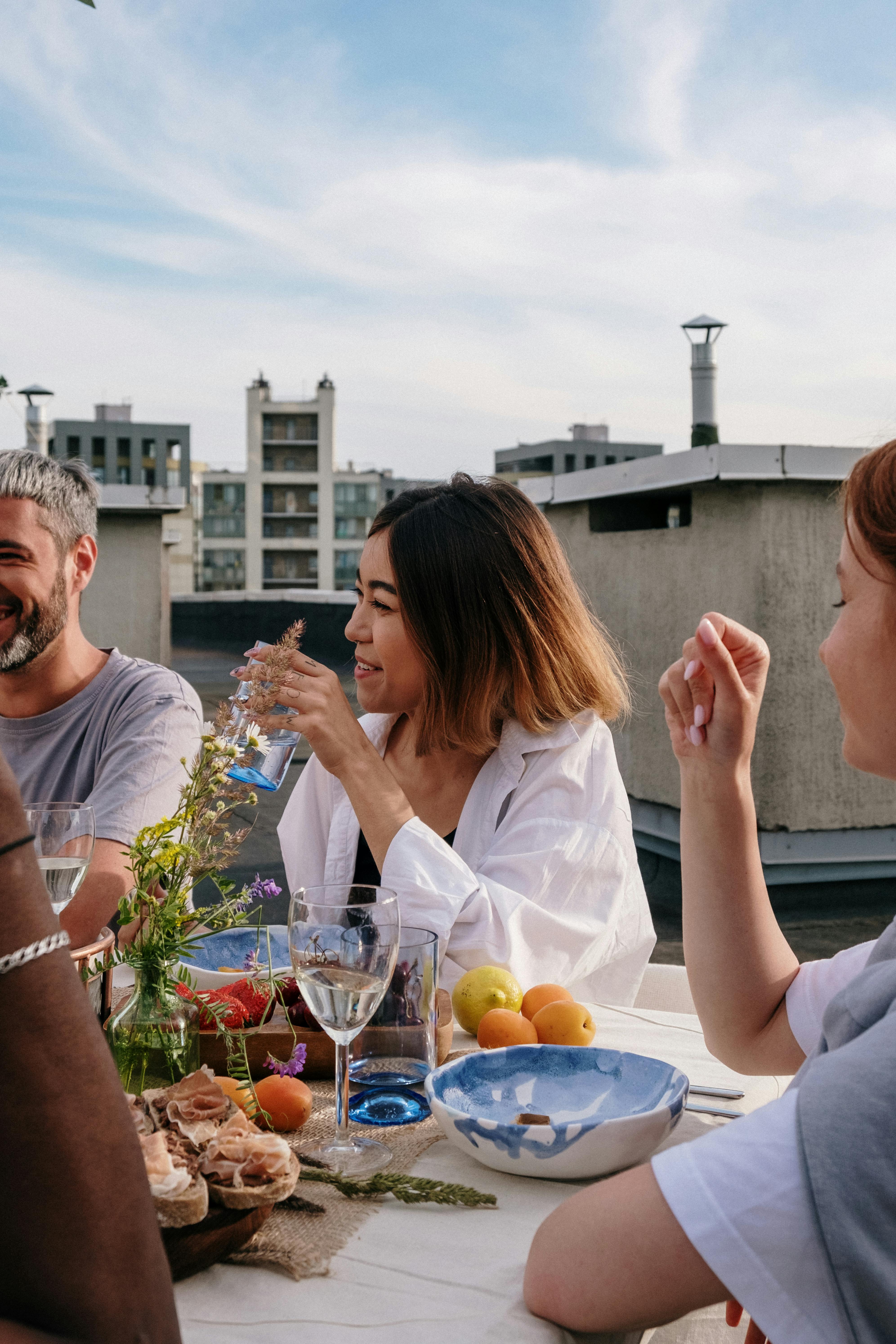 People talking and laughing at a table full of food | Source: Pexels