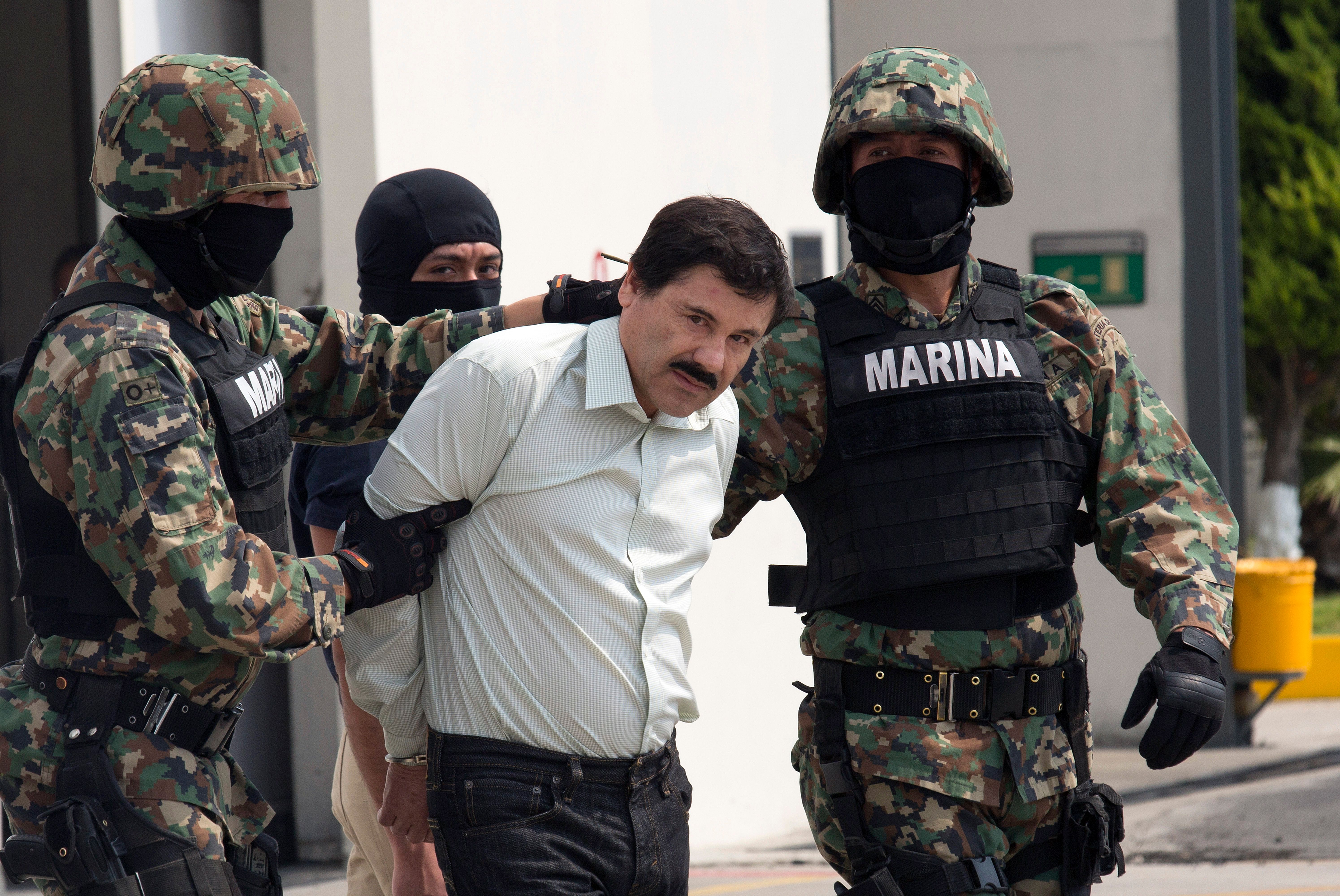 Joaquín "El Chapo" Guzmán es escoltado a un helicóptero por las fuerzas de seguridad mexicanas en el Aeropuerto Internacional de México el 22 de febrero de 2014. | Foto: Getty Images