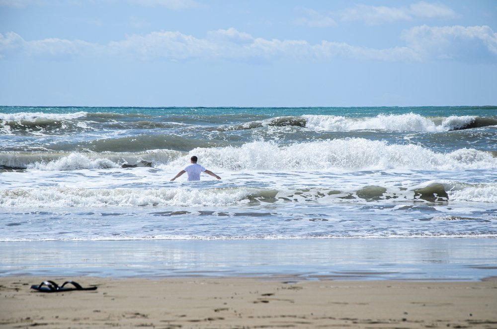 Hombre entrando al mar con oleaje fuerte.| Foto: Shutterstock