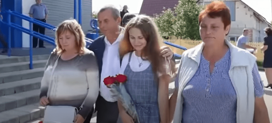 A screenshot of Yulia Gorina re-uniting with her parents, Viktor and Lyudmila Moiseenko | Photo:  youtube.com/Ruptly    youtube.com/CreepyWorld  
