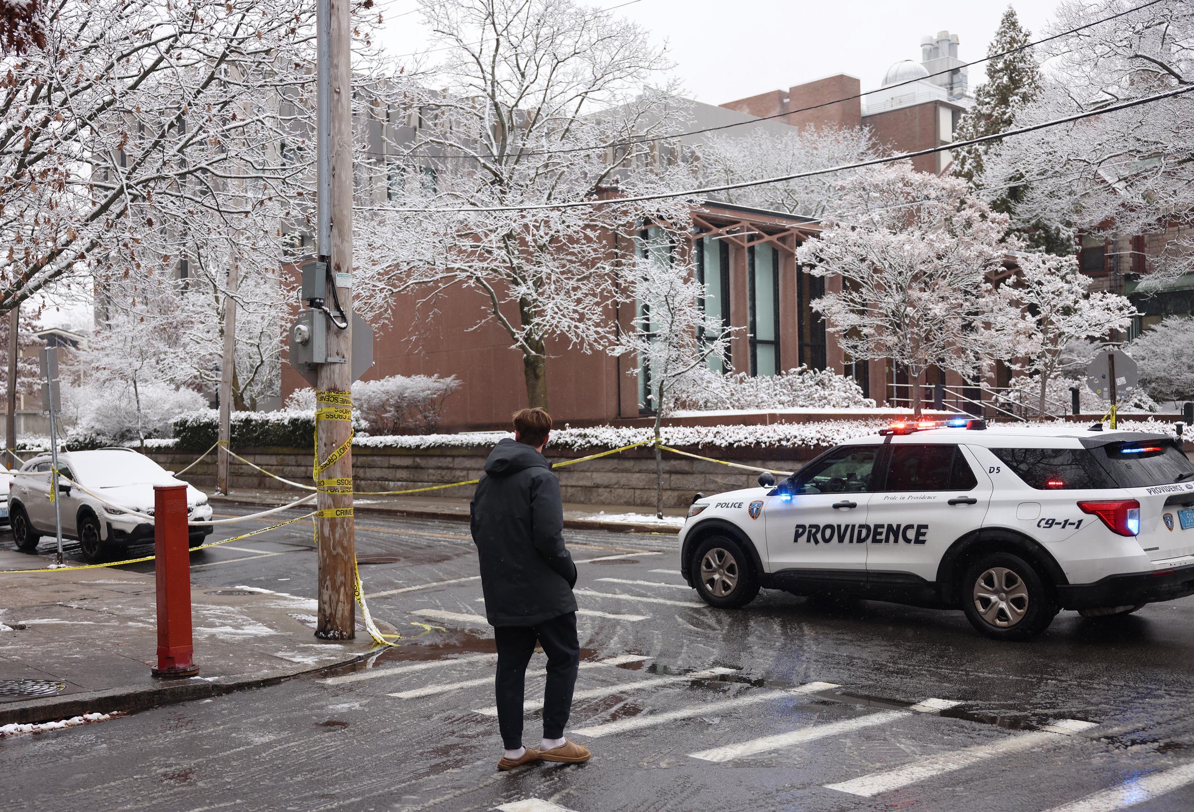 A person walks past crime scene tape outside the Barus & Holley School of Engineering at Brown University following a campus shooting that left two dead and nine injured on December 14, 2025. | Source: Getty Images