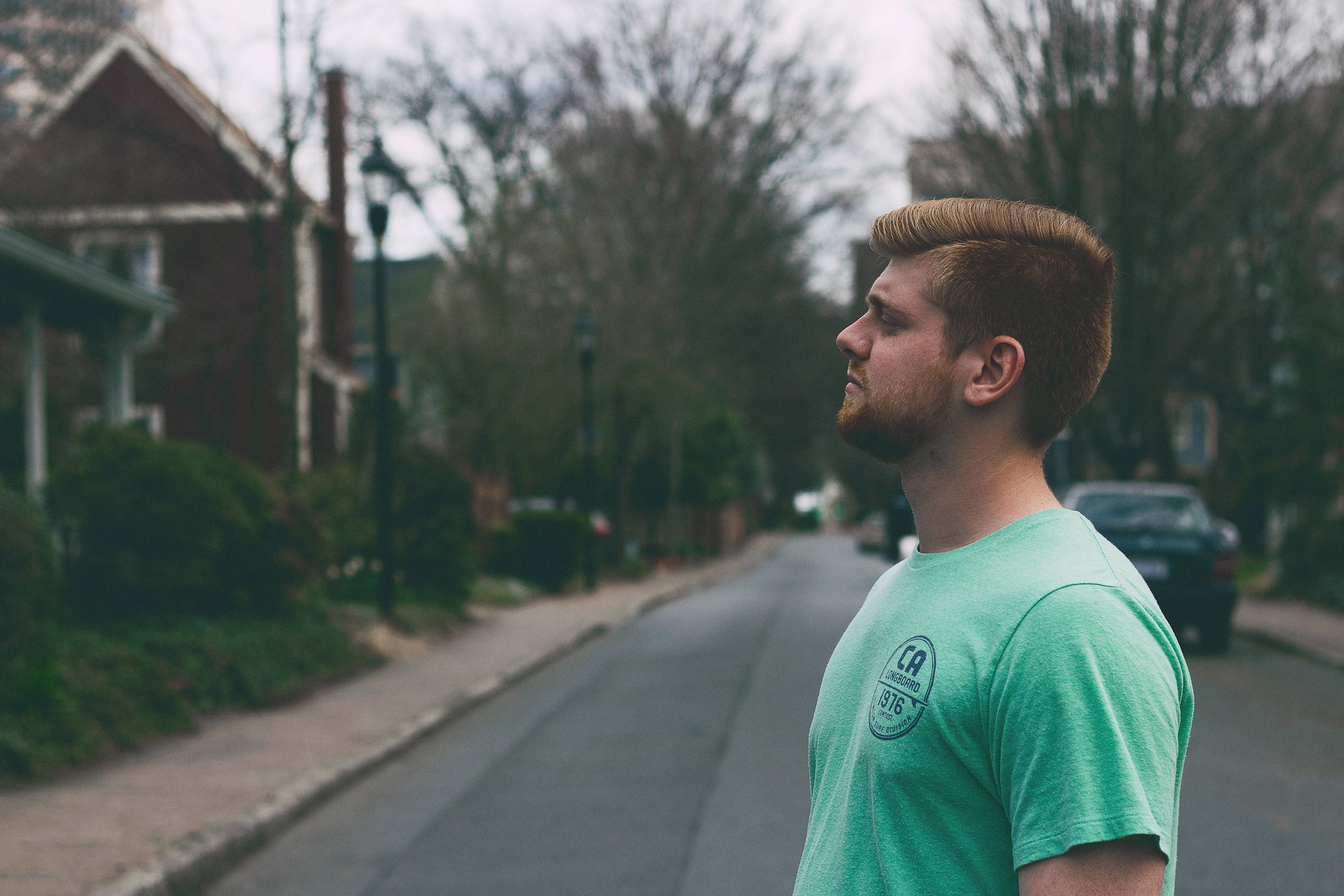 A man in a green t-shirt outside a house during daytime | Source: Unsplash