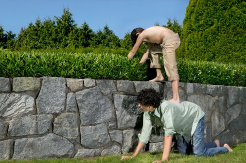 Photo of a boy standing on his friend's back | Photo: Getty Images