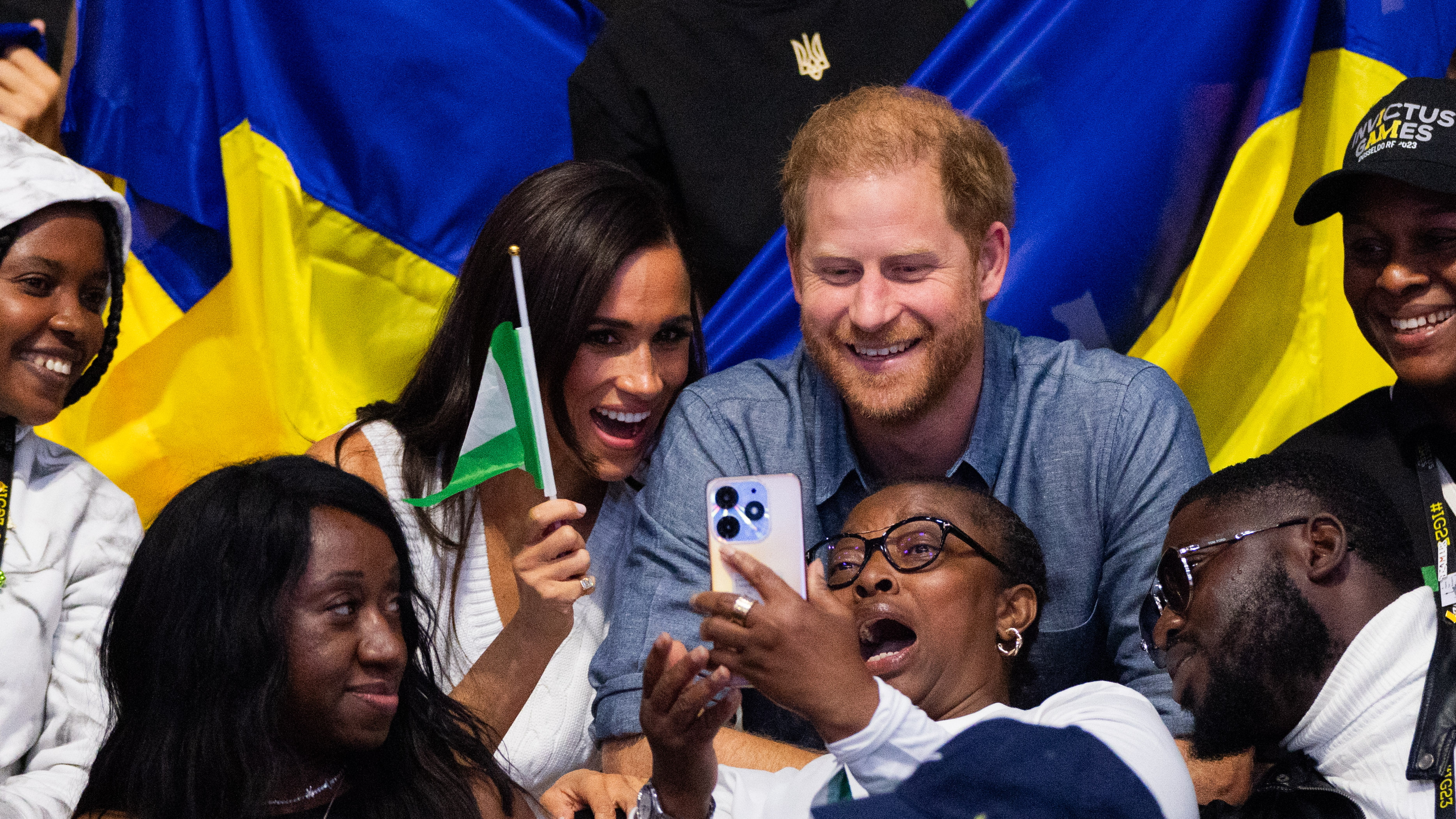 Meghan Markle waving the Nigerian flag, with Prince Harry by her side, as they interact with Nigerian fans during the 6th Invictus Games in North Rhine-Westphalia, Duesseldorf on September 14, 2023 | Source: Getty Images
