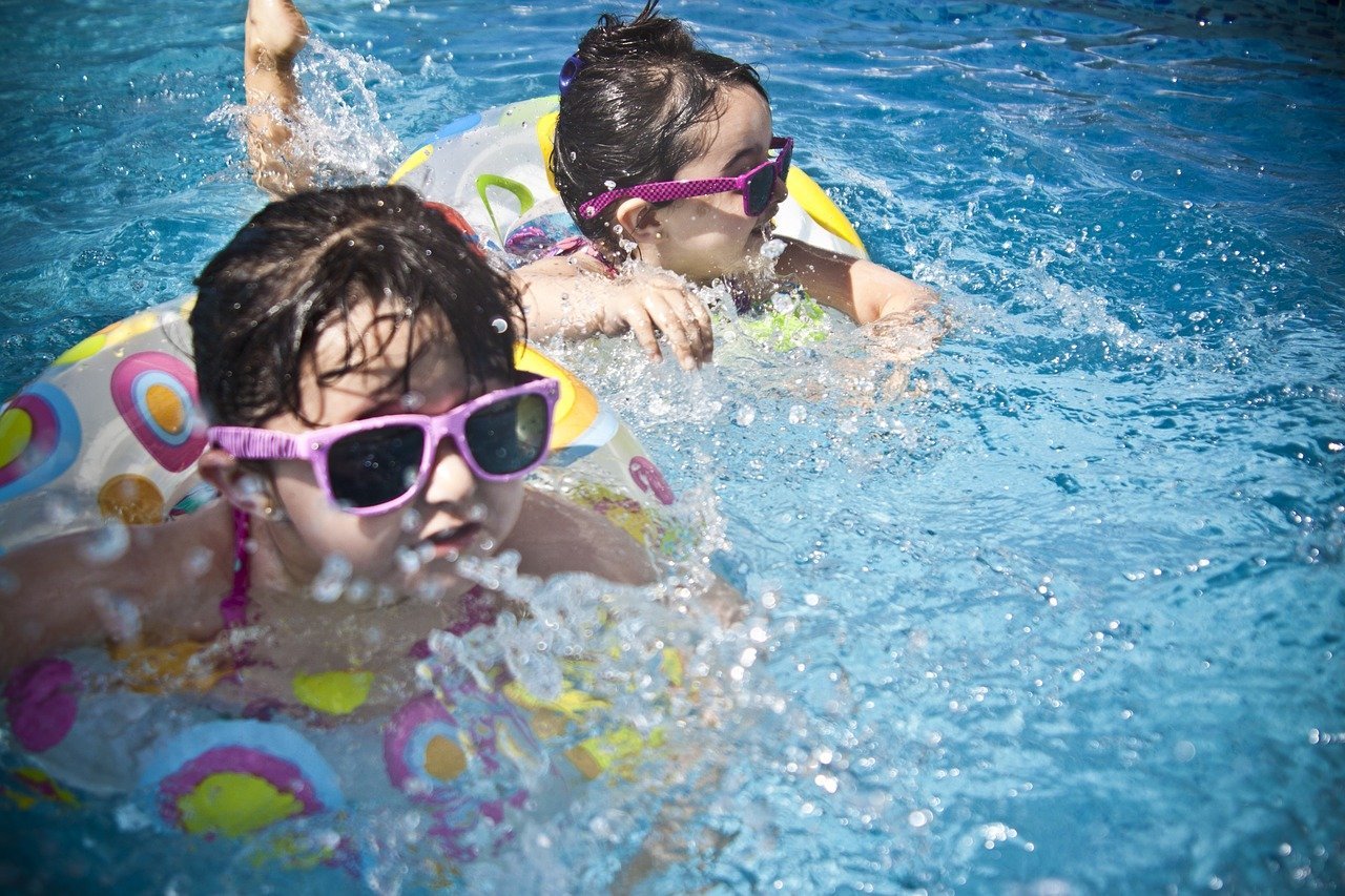 Young children wearing sunglasses and swimming gear in a pool | Photo: Pixabay/Pexels 