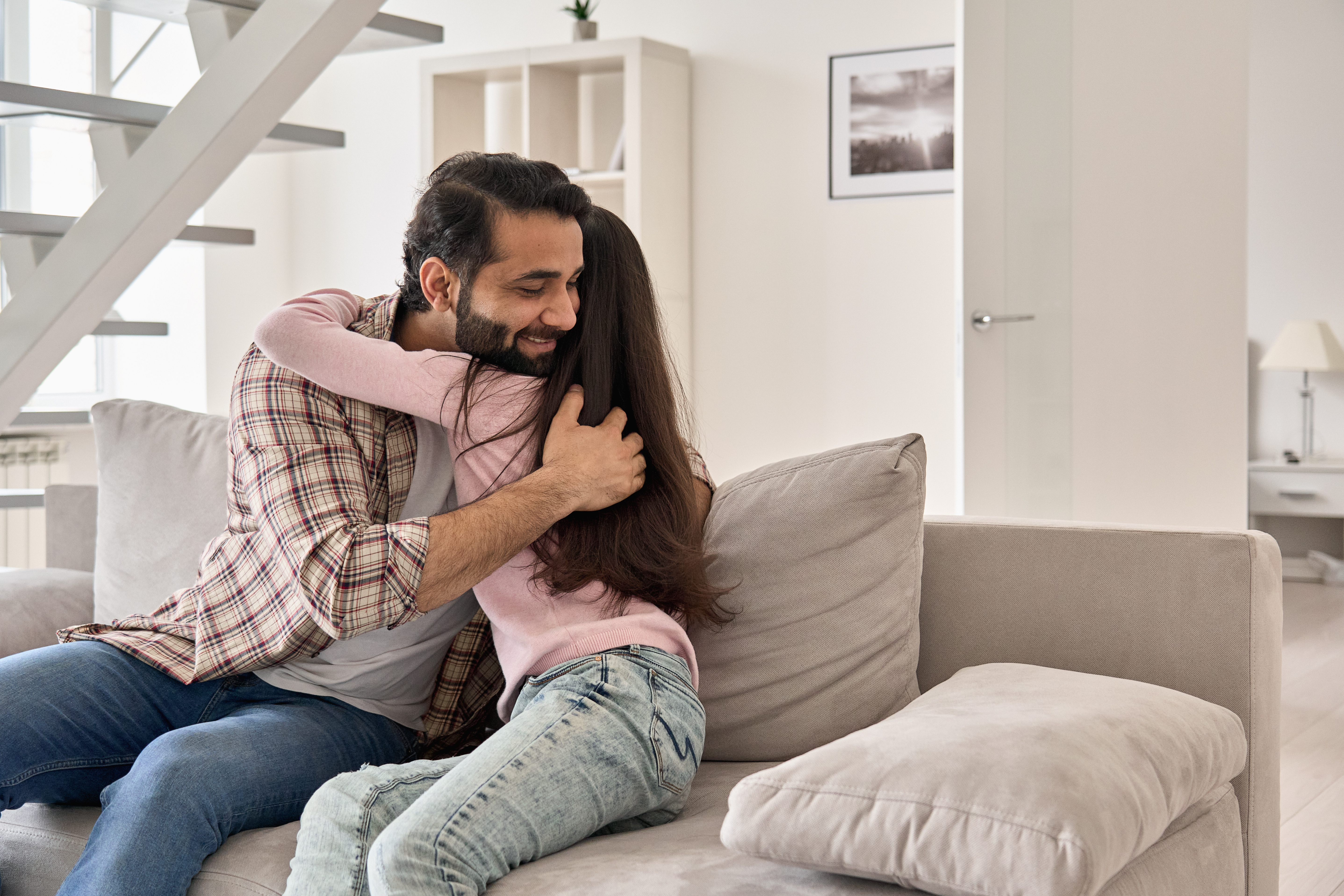 A happy father embracing his teenage daughter at home | Source: Shutterstock