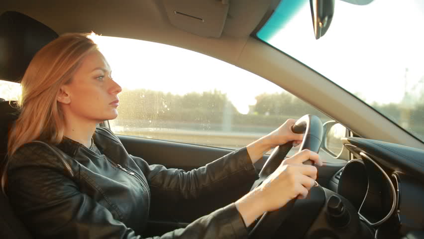 A blonde young woman looking serious while driving a car | Photo: Shutterstock.com