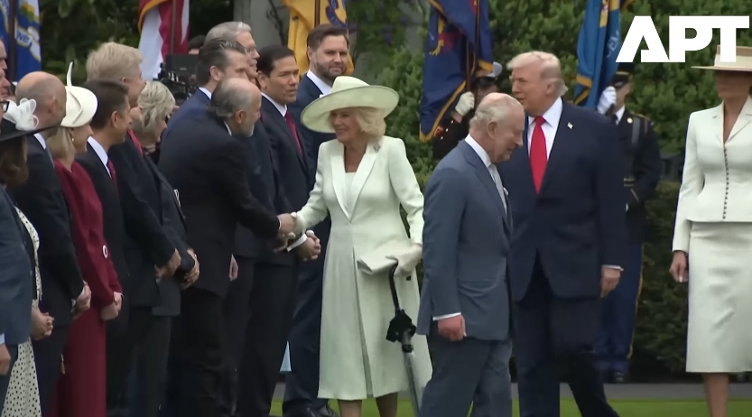 Queen Camilla maintains her steady rhythm of greetings, engaging warmly with each official, while Donald Trump approaches from behind and King Charles III proceeds forward, momentarily separating their positions in the line. | Source: YouTube/APT