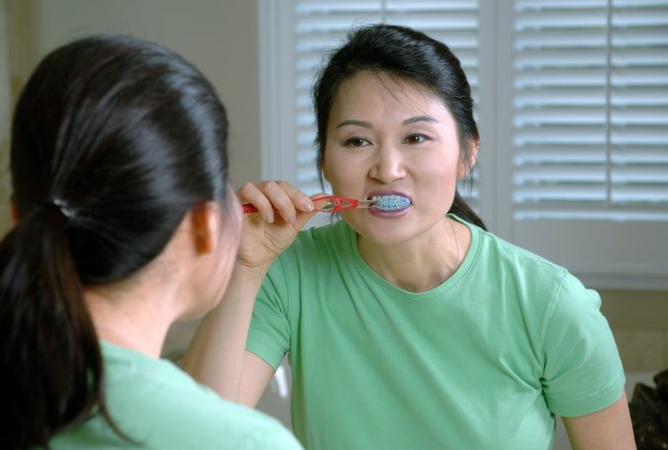 Une femme entrain de brosser ses dents. | Photo : Unsplash