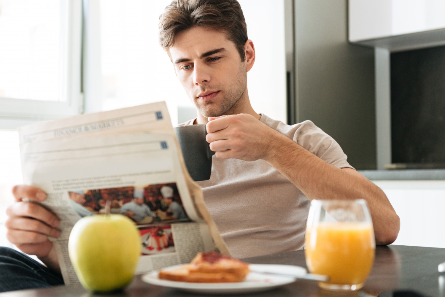 Man in the kitchen with his coffee and newspaper | Source: Freepik