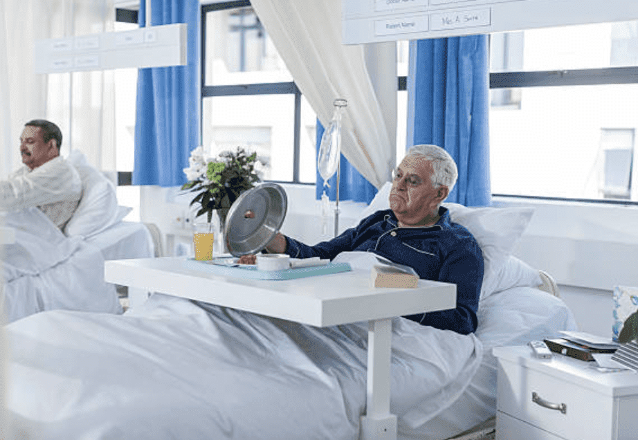 Senior patient looking at his meal in hospital bed | Source: Getty Images