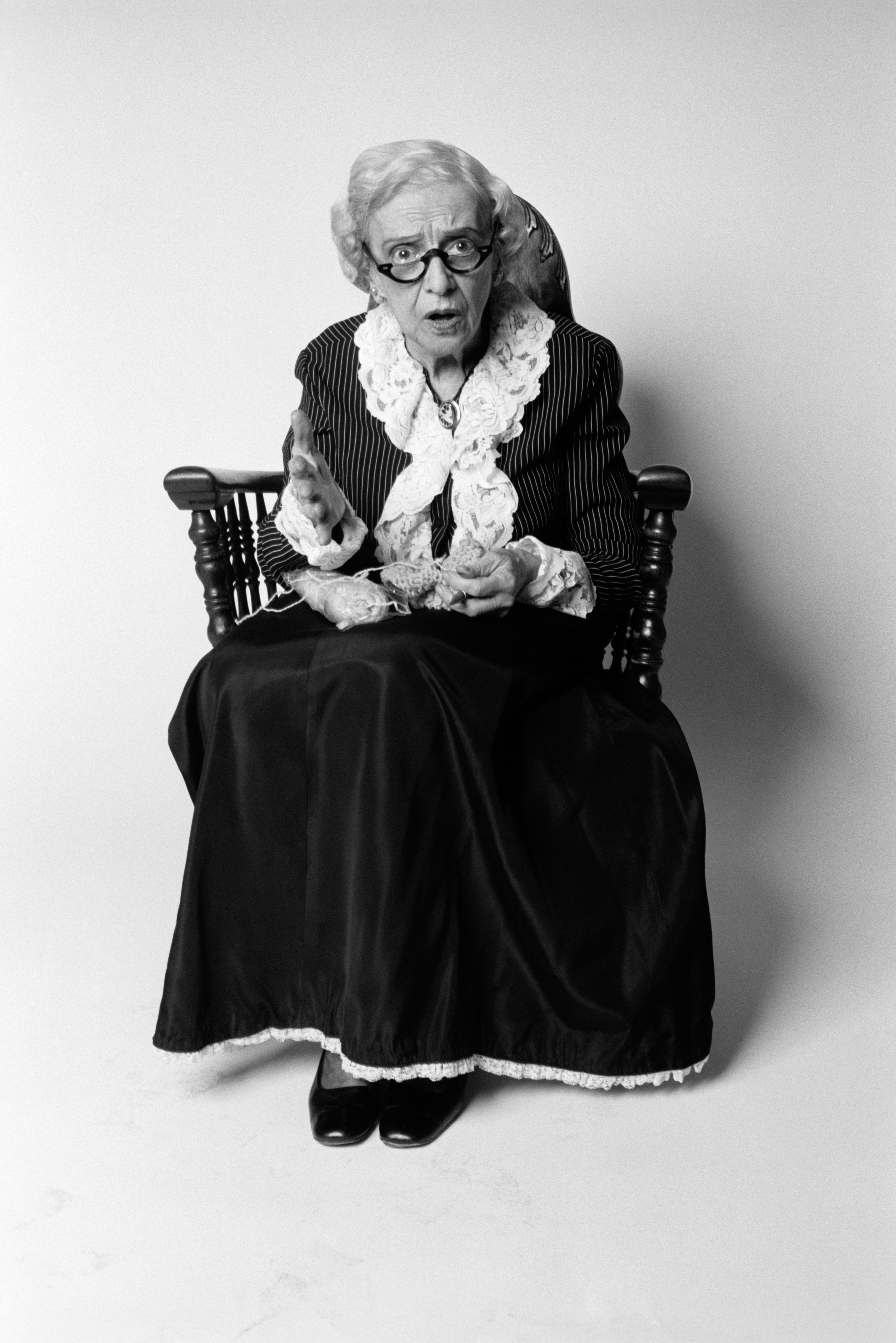 Shocked senior woman sitting in a chair with knitting in her lap | Source: Getty Images