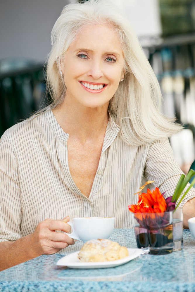 Mujer risueña disfrutando de su desayuno. | Foto: Shutterstock