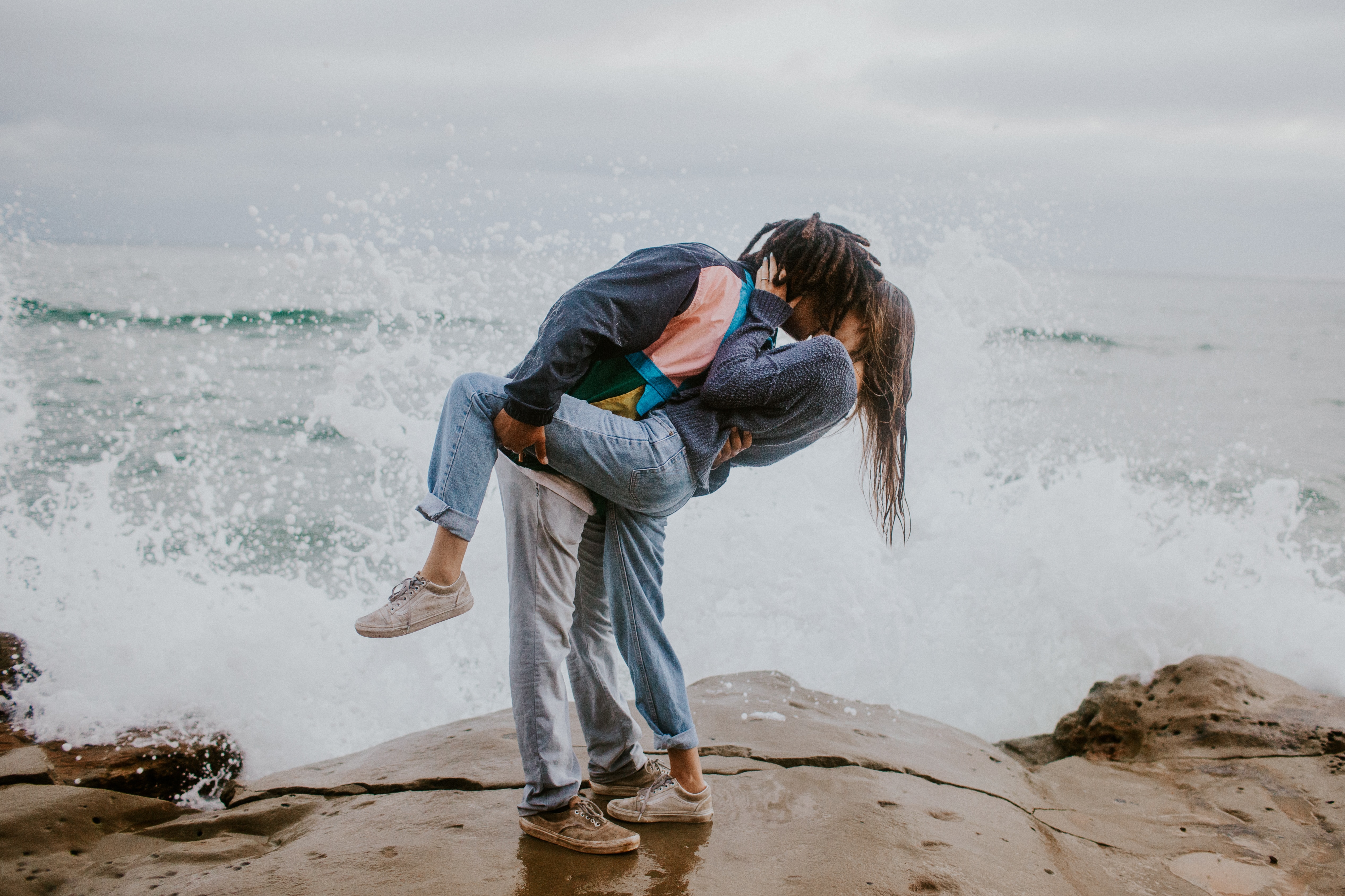 A couple kissing in front of the ocean. | Source: Unsplash