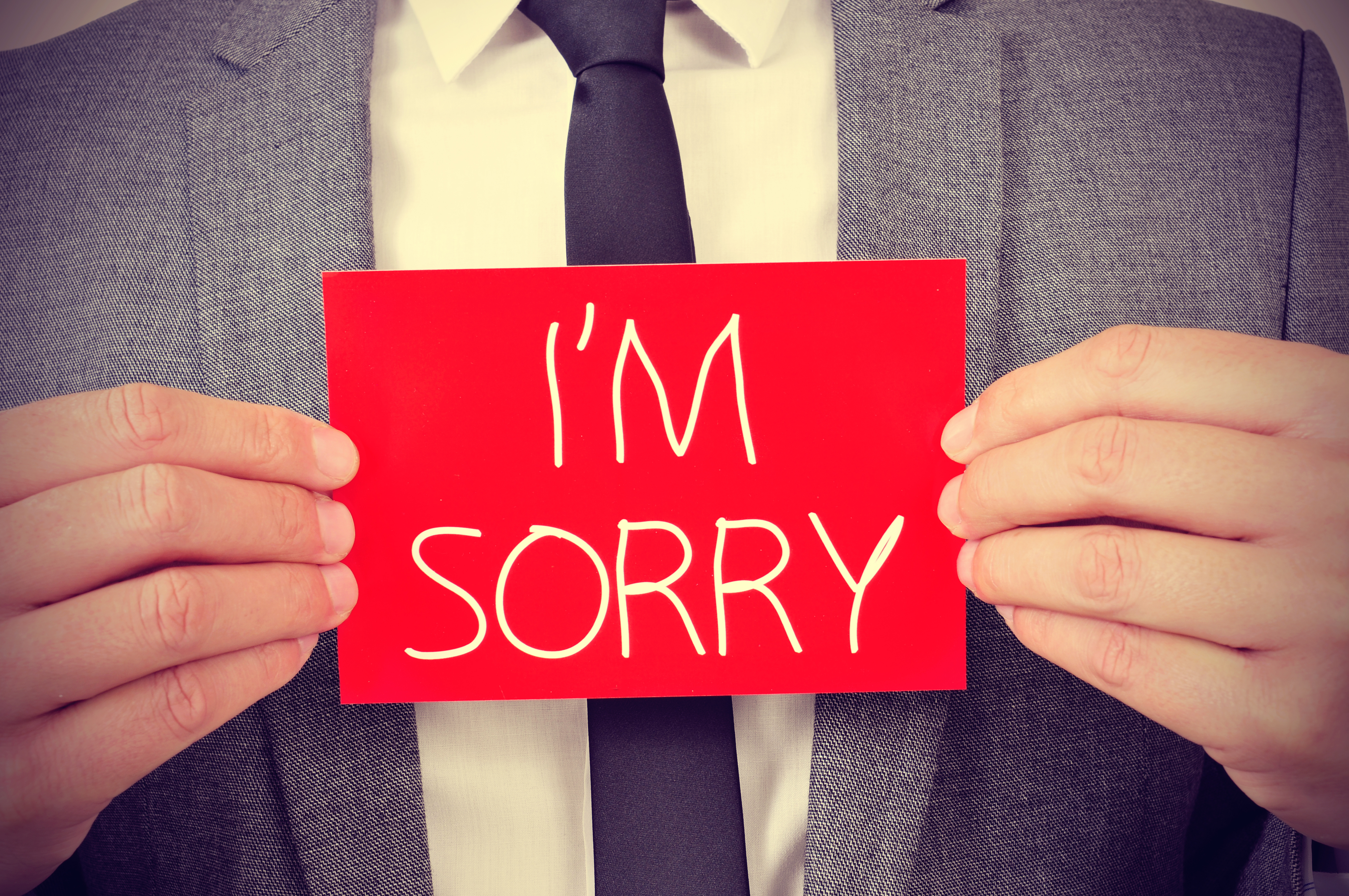 man with an apology note | Shutterstock