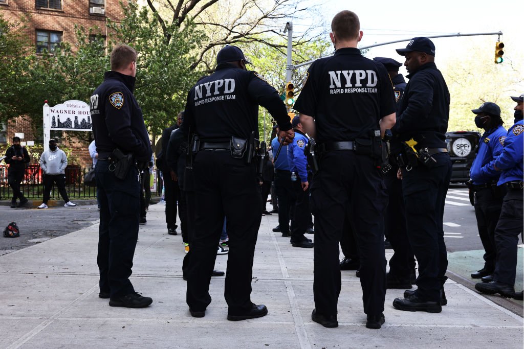 NYPD officers await the start of a peace walk to denounce the rise of gun violence in the city in the Harlem neighborhood on April 30, 2021 | Photo: Getty Images