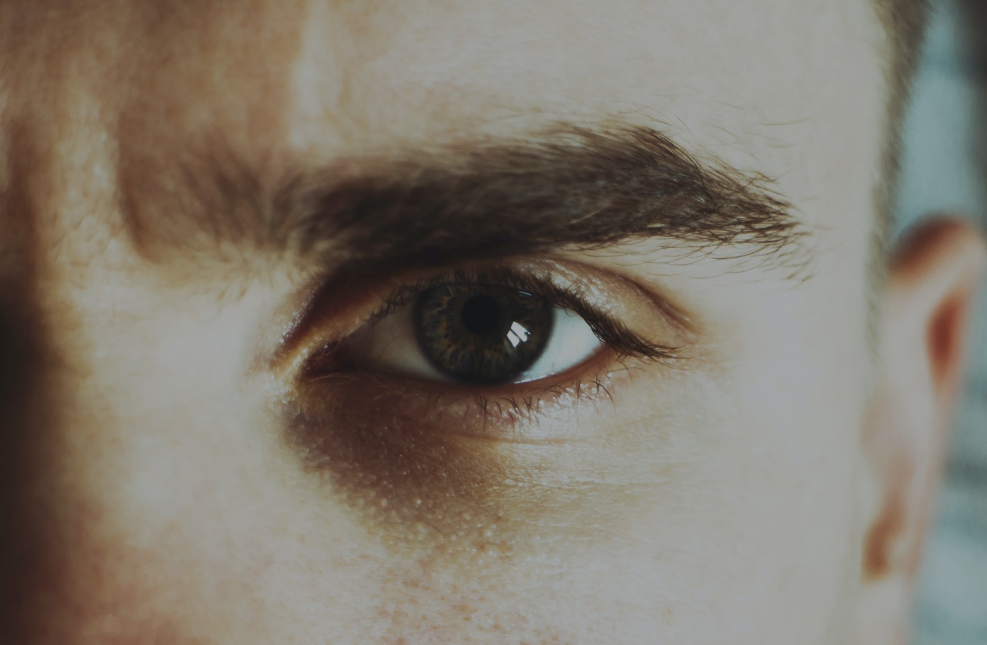 A closeup of a man's eye with a frown on his brow | Source: Unsplash