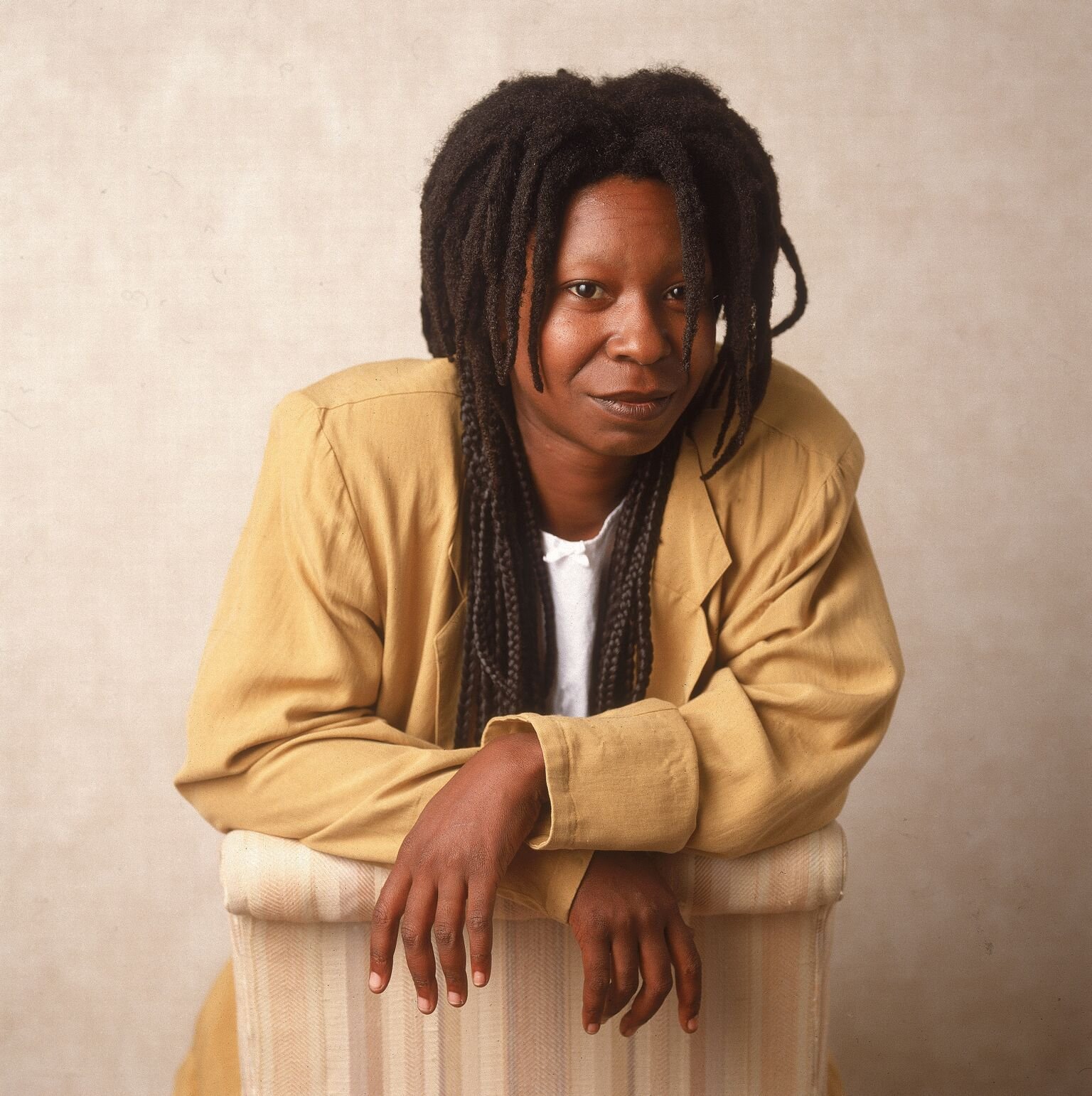  American actor and comedian Whoopi Goldberg leaning on a chair, 1988 | Getty Images