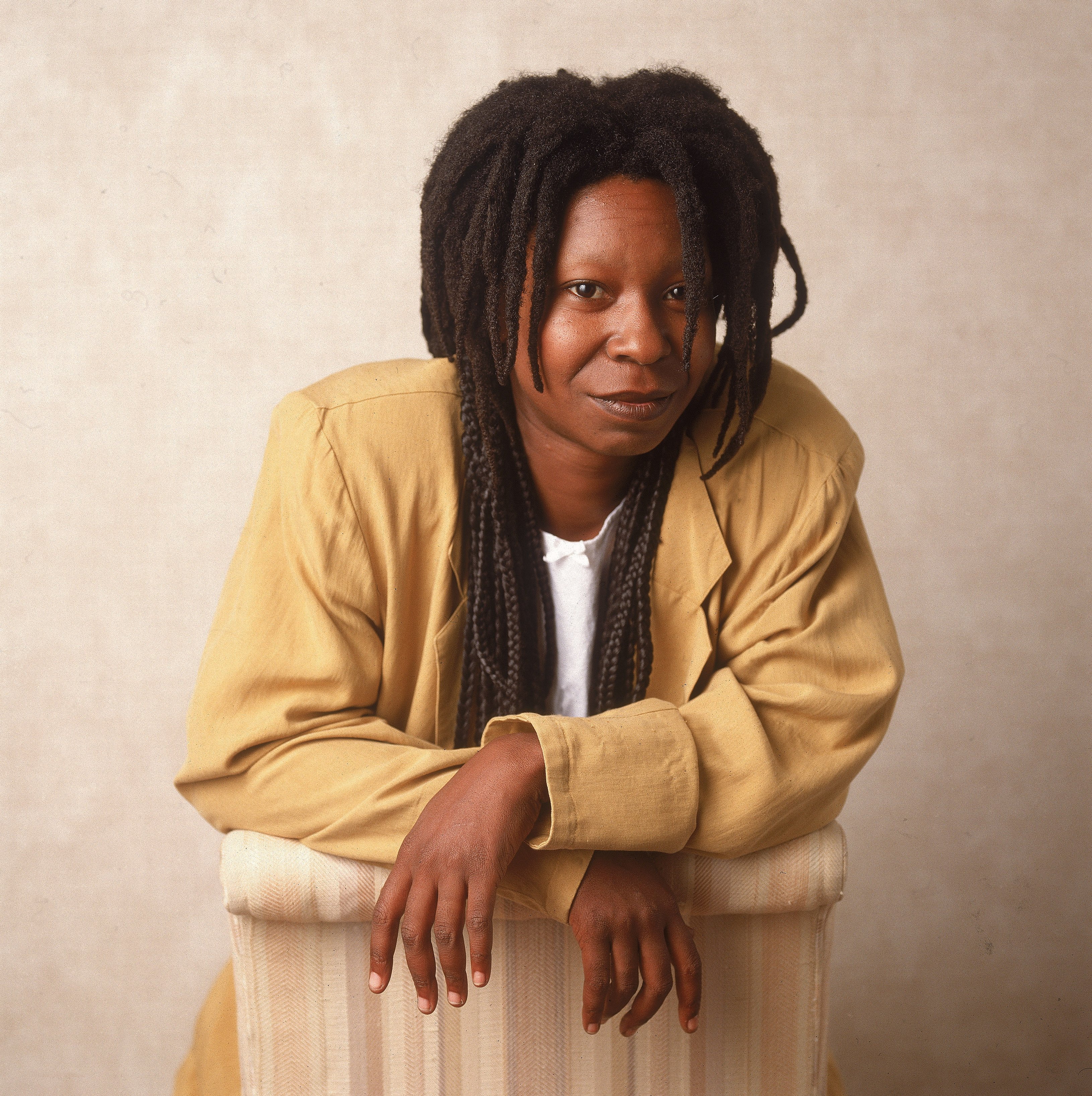 Studio portrait of Whoopi Goldberg leaning on a chair, 1988. |Photo: Getty Images