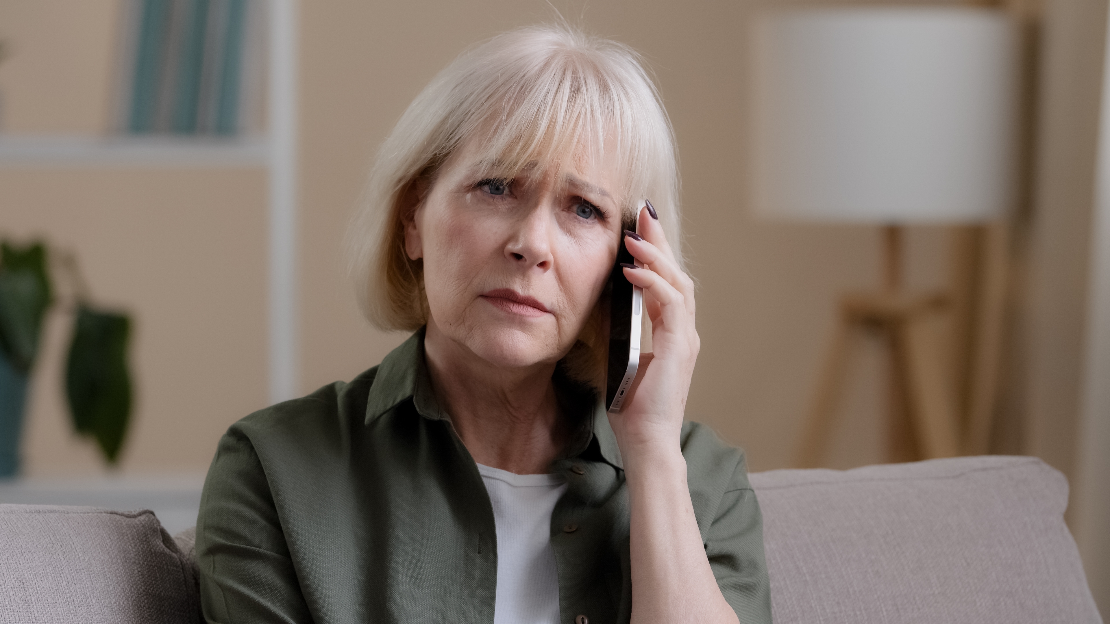 A distraught senior woman talking on her phone | Source: Shutterstock