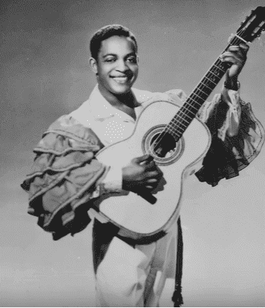 A young Irving Burgie playing the guitar | Photo: New York Daily News