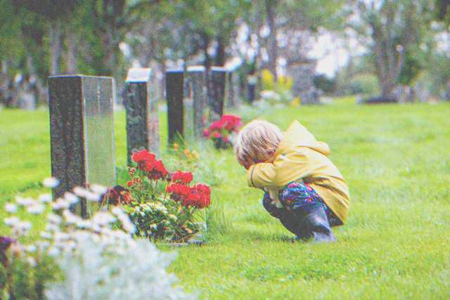 Crying little boy near a grave. | Source: Shutterstock