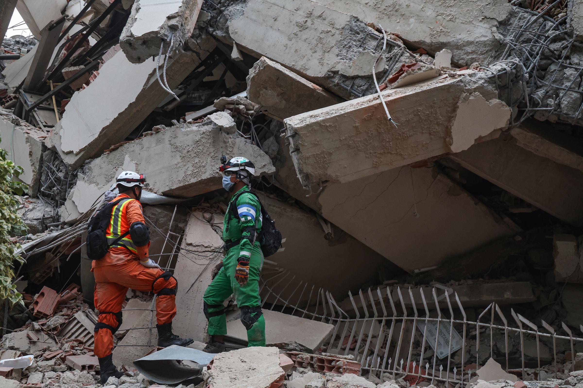Rescue workers examine the remains of a collapsed building in La Guaira after the powerful earthquakes. The unstable debris made recovery operations slow and difficult. | Source: Getty Images