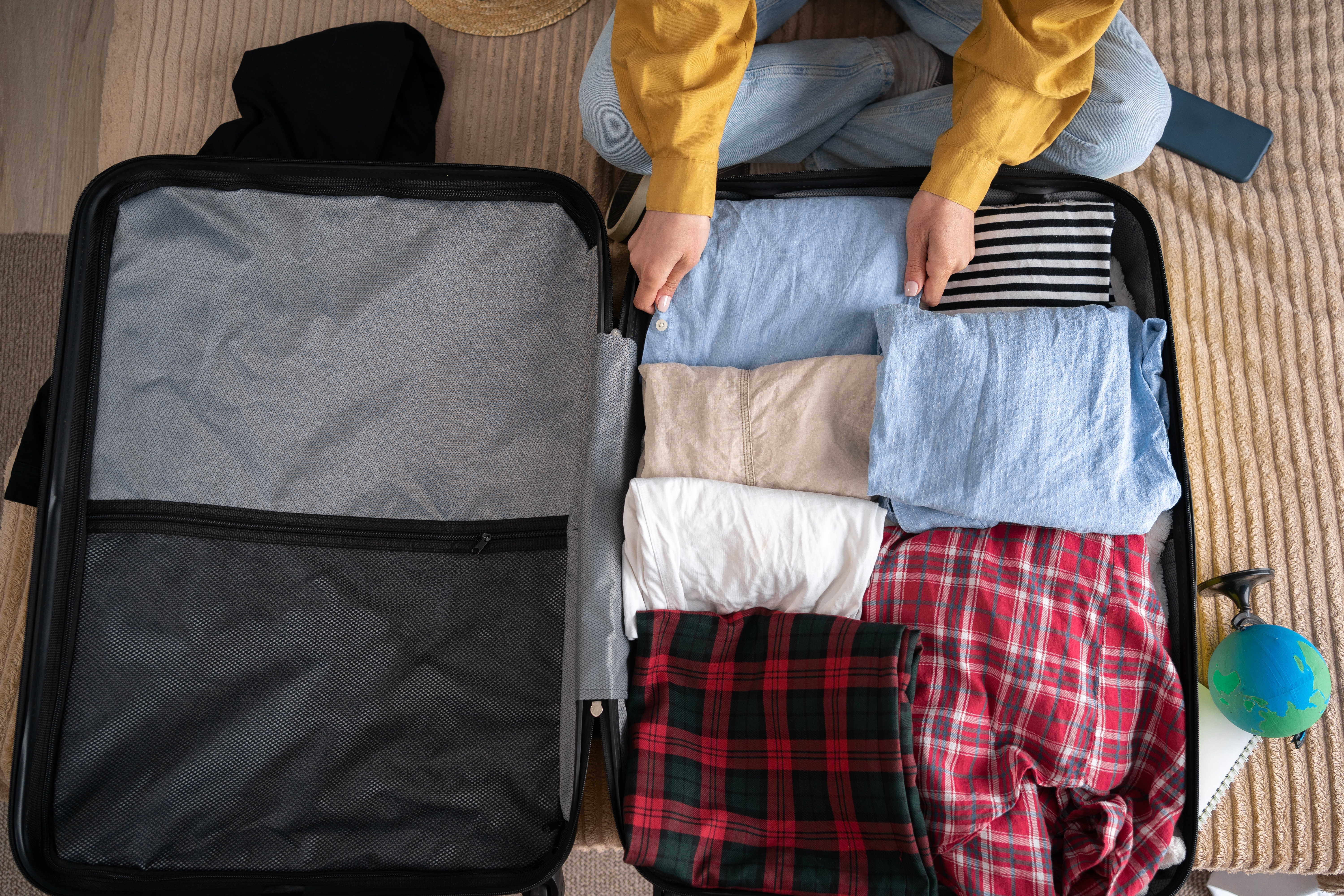 A woman packing her clothes | Source: Shutterstock