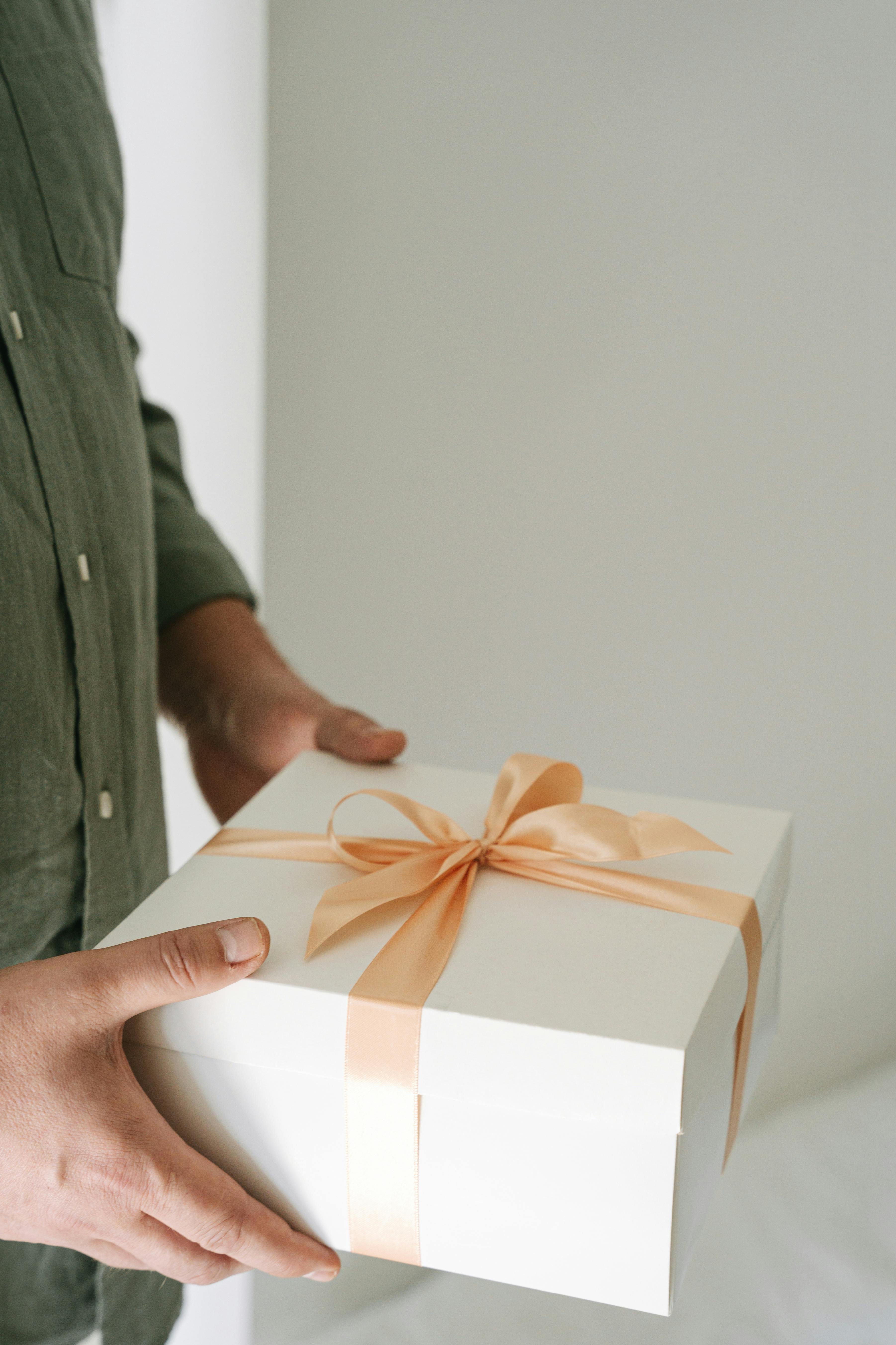 A man holding a wrapped present | Source: Pexels