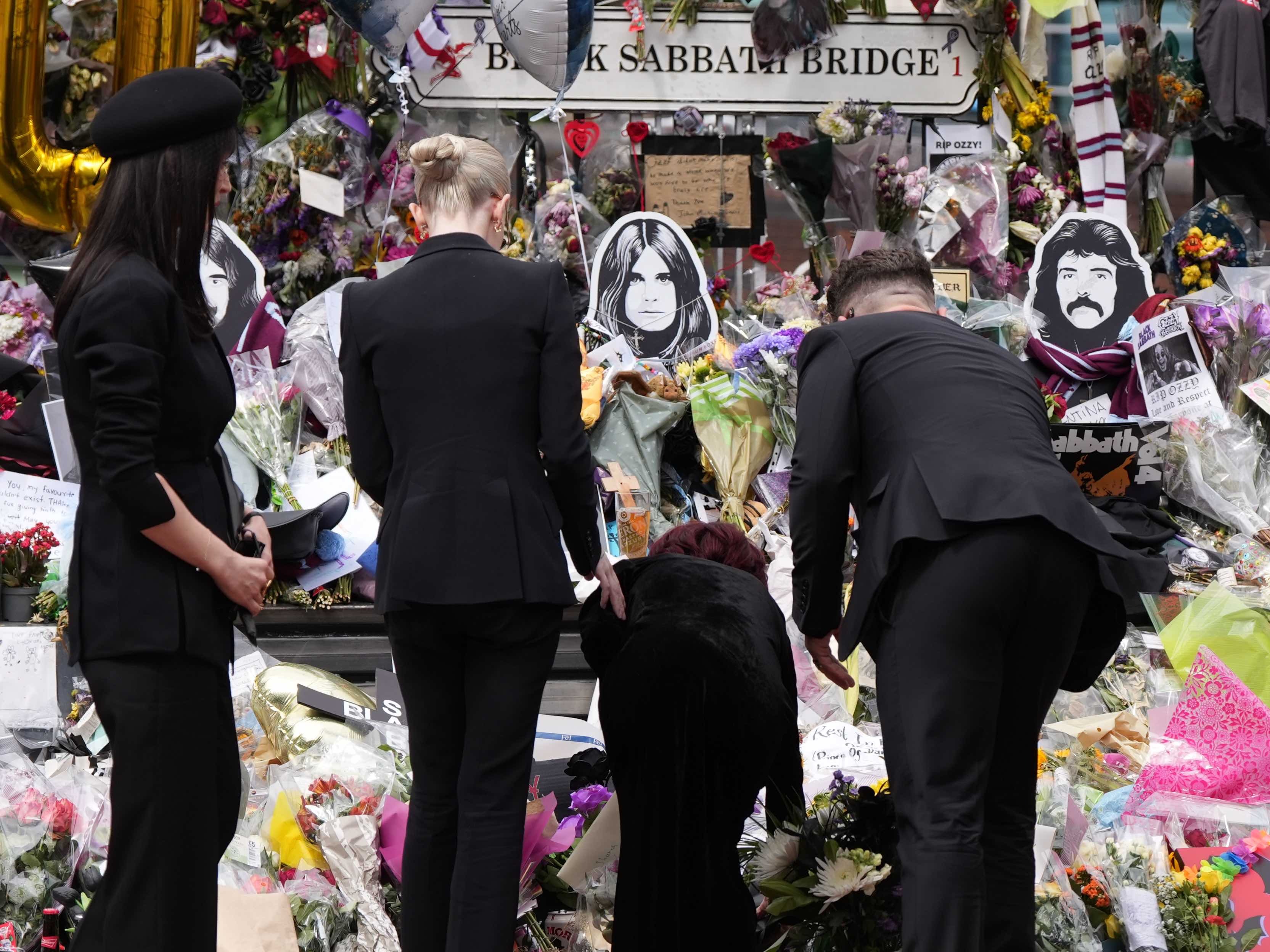 Ozzy Osbourne's widow, Sharon Osbourne and their children look at floral tributes during Ozzy's funeral in Birmingham on 30 July 2025 | Source: Getty Images