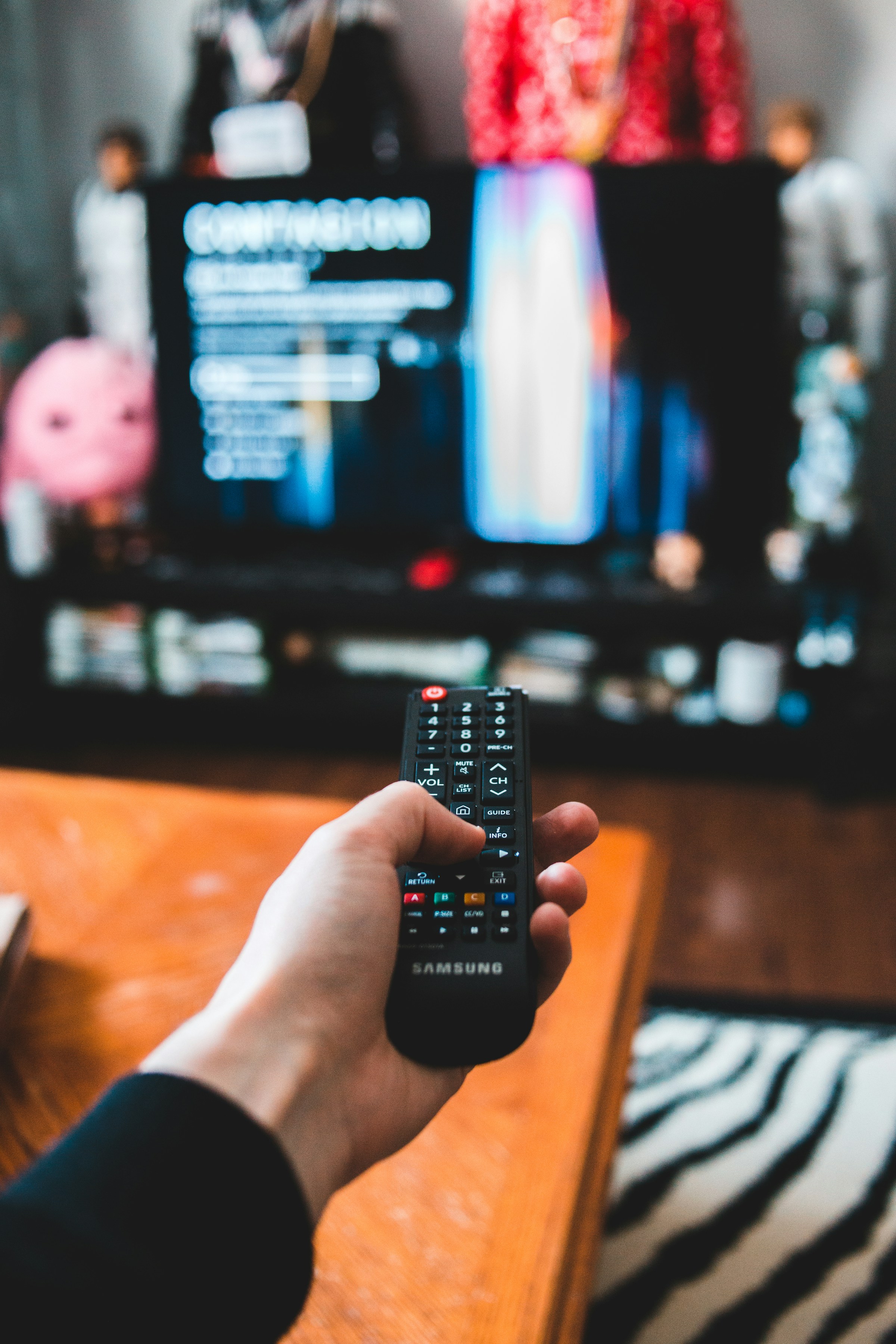 A person holding a TV remote | Source: Unsplash