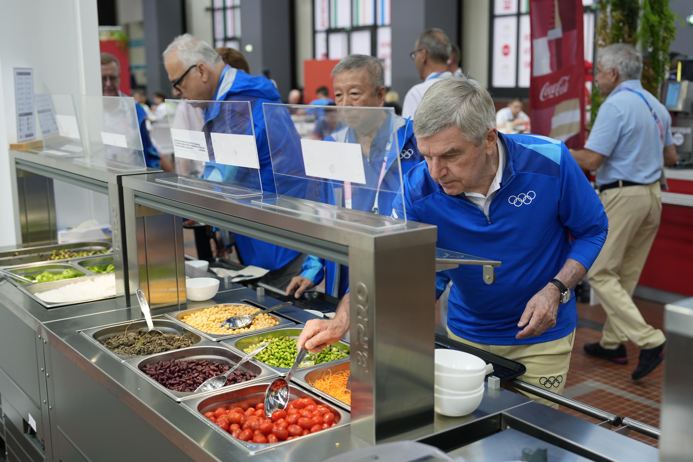 IOC President Thomas Bach at a salad bar in the Olympic Village on July 22, 2024, in Paris, France. | Source: Getty Images