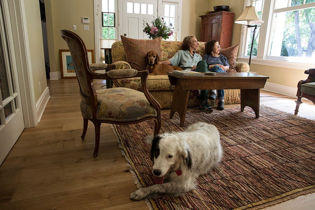 Linda Hunt, a la derecha, con su pareja Karen Klein y sus perros sentados en la sala de estar de su casa recientemente renovada en Craftsman, 13 de septiembre de 2014 | Foto: Getty Images