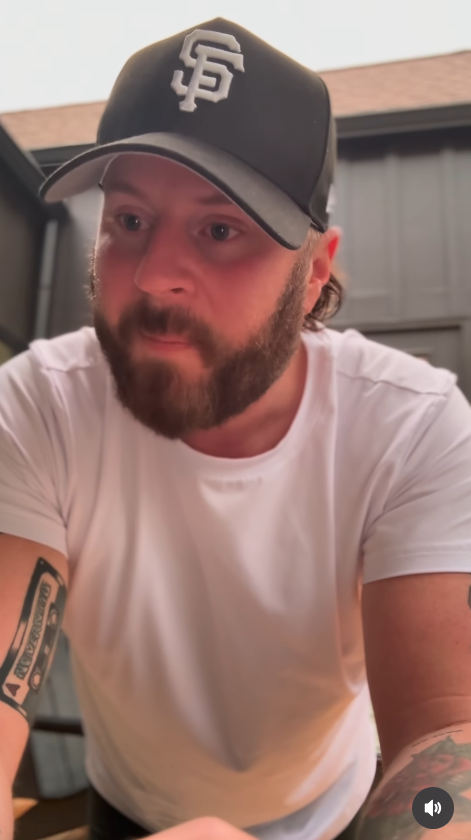 Nate Smith turns slightly to the side while leaning toward the camera, his fitted white T-shirt and tattooed arms further highlighting the changes in his physique. | Source: Instagram/natesmith