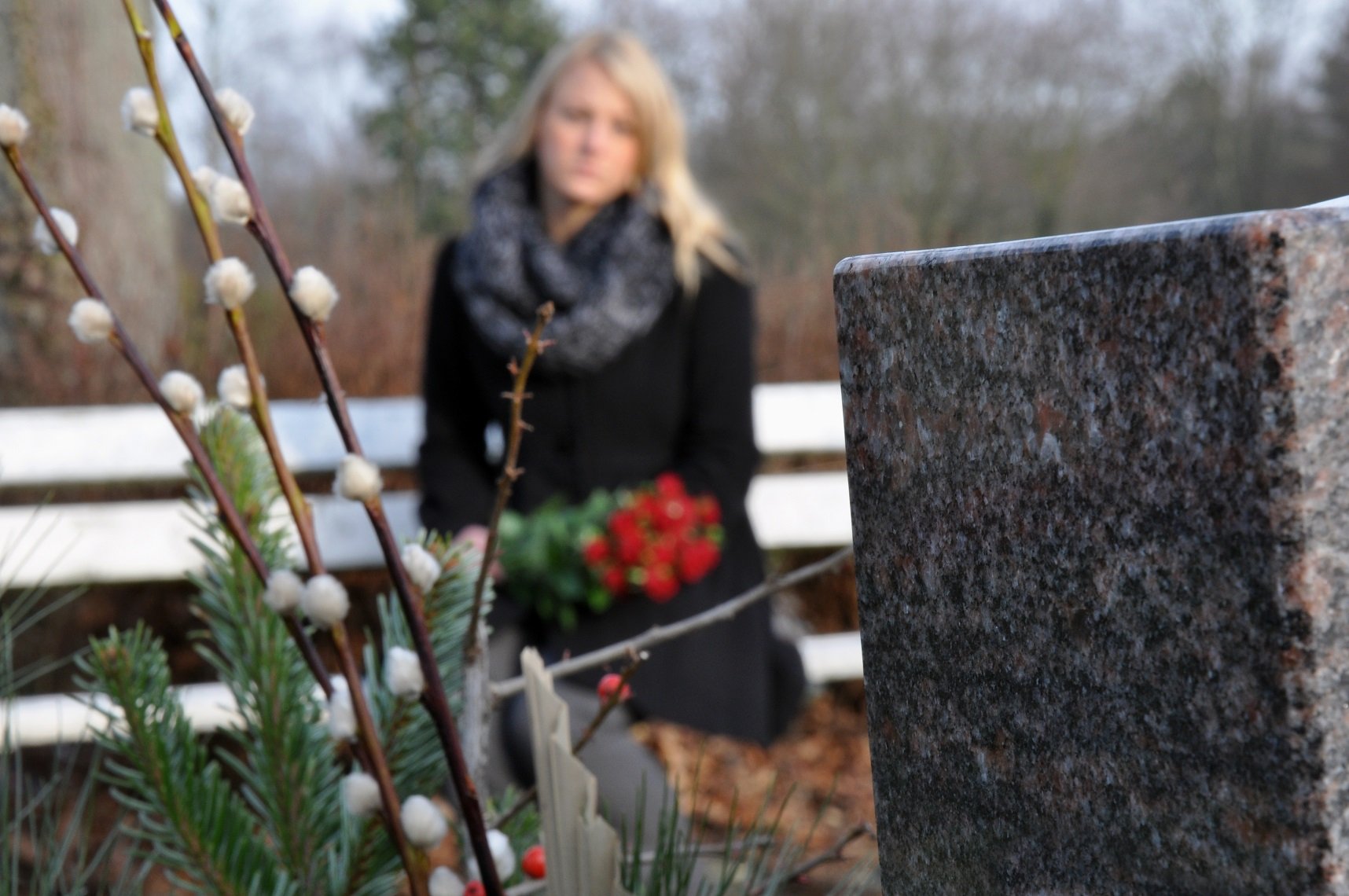 Mujer visita tumba en cementerio || Fuente: Shutterstock