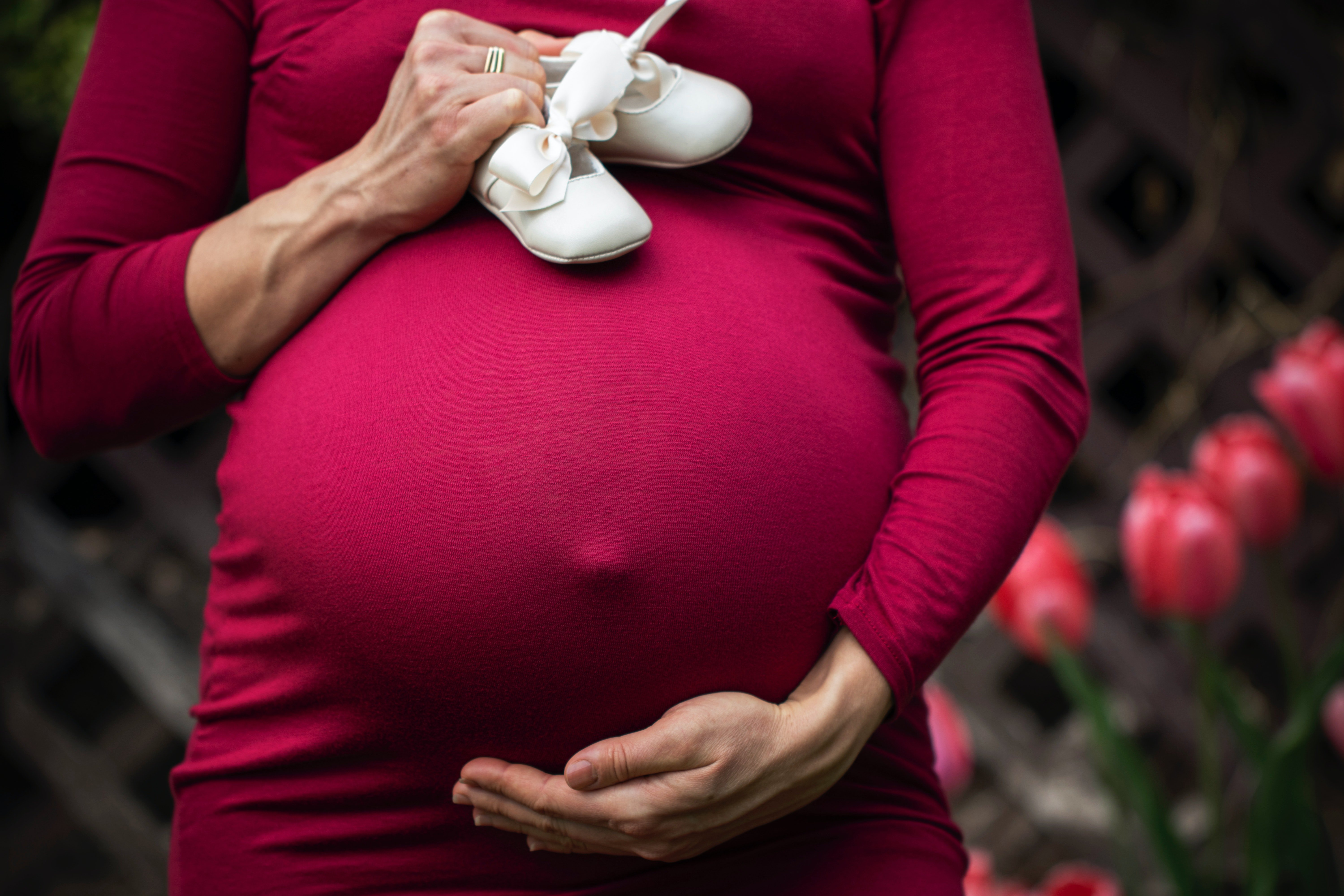 Pregnant woman holding baby's shoes. | Source: Pexels