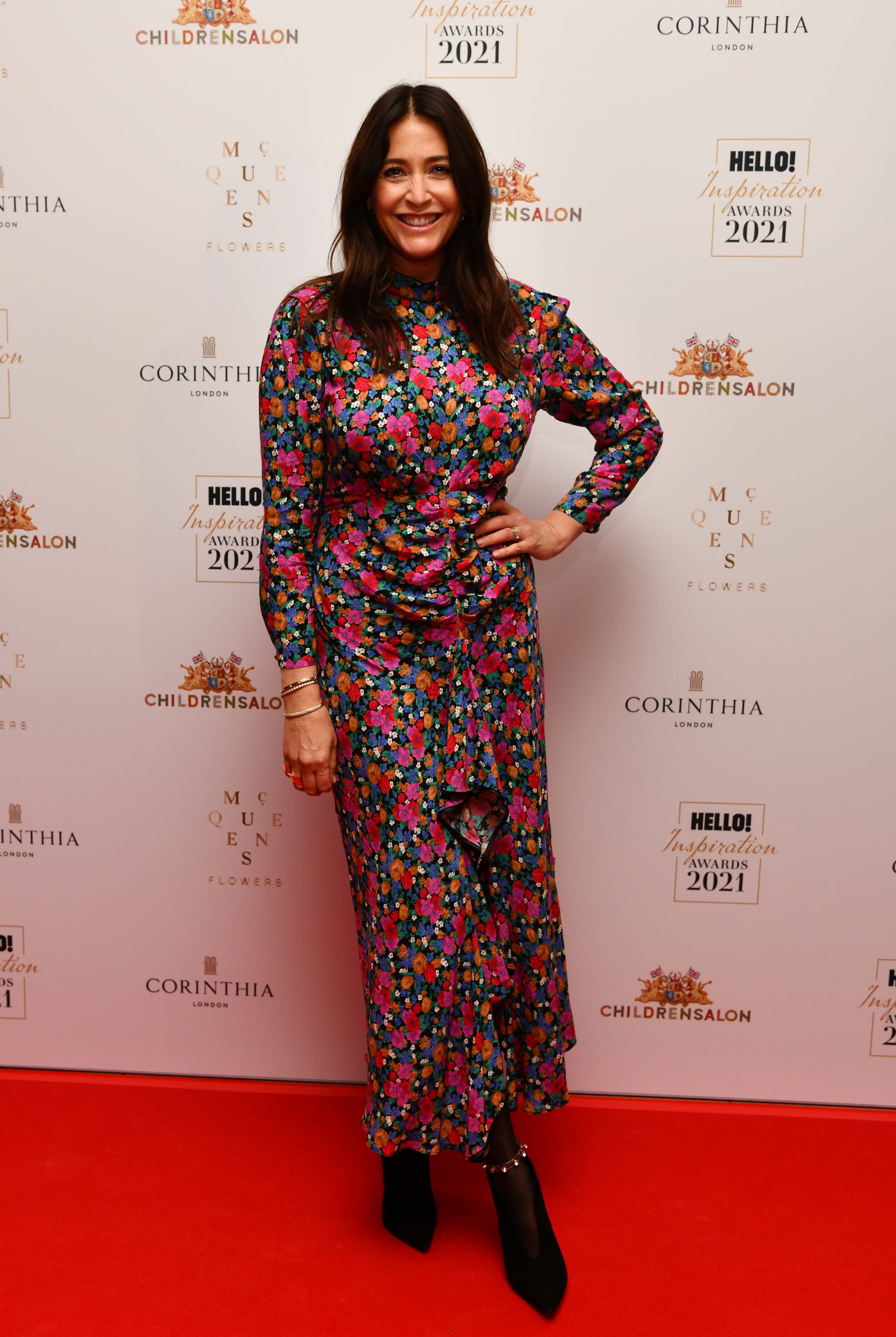 Hello! Inspiration Awards, Corinthia London, 5 October 2021 — Beaming on the red carpet, Snowdon wears a long-sleeved, high-neck dark floral midi dress in bold shades of pink, orange, blue and green, with a ruched front panel and a ruffled asymmetric hem, paired with embellished black ankle boots.