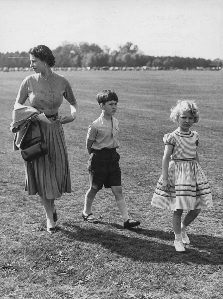 Queen Elizabeth II and her children Princess Anne and Prince Charles arrive to watch Prince Philip play polo for the Household Brigade at Windsor Great Park, England on May 14, 1956. | Source: Paul Popper/Popperfoto/Getty Images