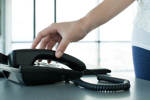Femme décrochant le téléphone. | Photo : Getty Images