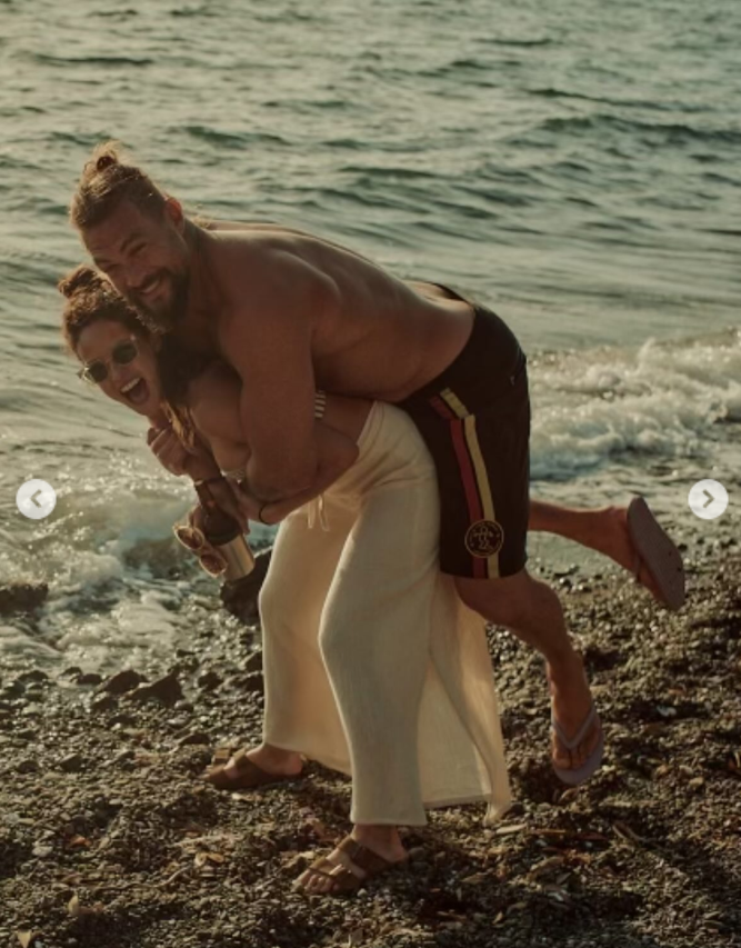 Jason Momoa and Adria Arjona have a playful moment on the beach, from a post dated August 1, 2025. | Source: Instagram/adriaarjona