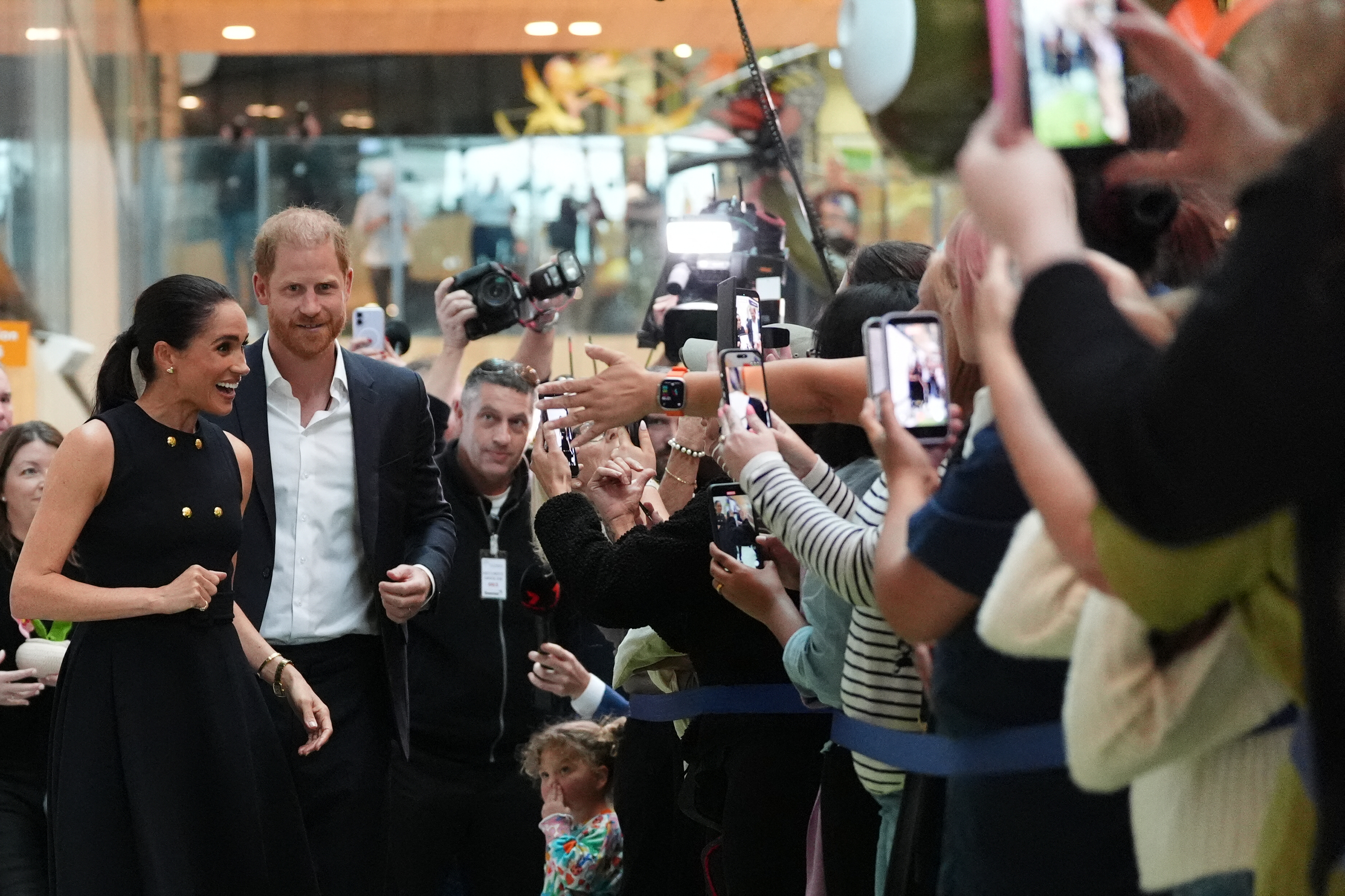 Prince Harry and Meghan Markle are surrounded by a dense crowd of well-wishers as they greet members of the public during their hospital visit in Melbourne on 14 April 2026. | Source: Getty Images