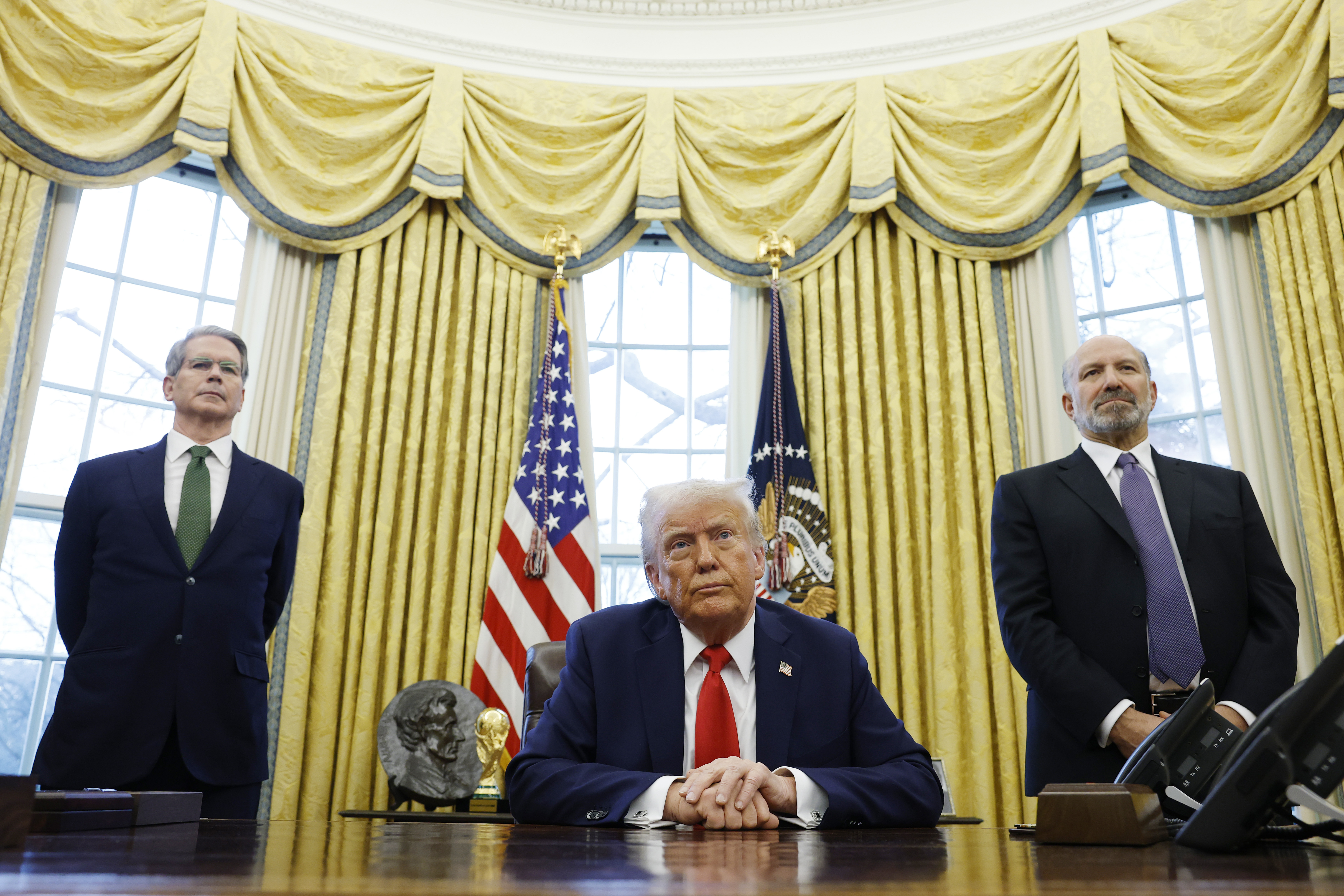 US Secretary of Treasury Scott Bessent and Howard Lutnick, US President Donald Trump's nominee for Commerce Secretary, stand behind Donald Trump as he speaks to reporters. | Source: Getty Images