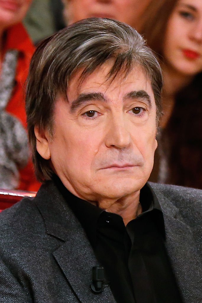 Serge Lama présente son livre "Un homme de paroles - L'intégrale de mes chansons" lors de l'émission de télévision française "Vivement Dimanche" au Pavillon Gabriel le 26 novembre 2014 à Paris, France. | Photo : Getty Images