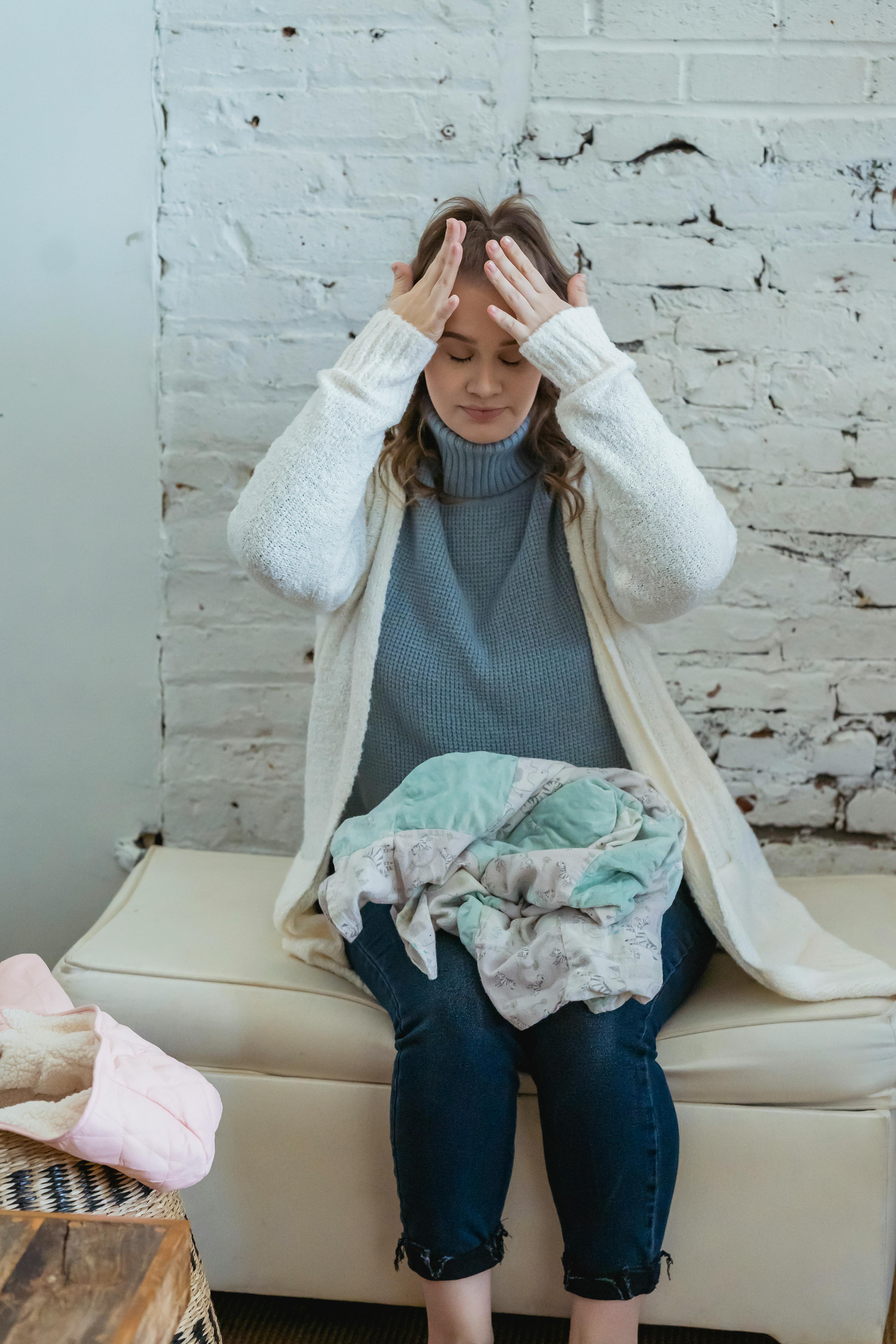 Woman rubbing her forehead with her hands in frustration | Source: Pexels